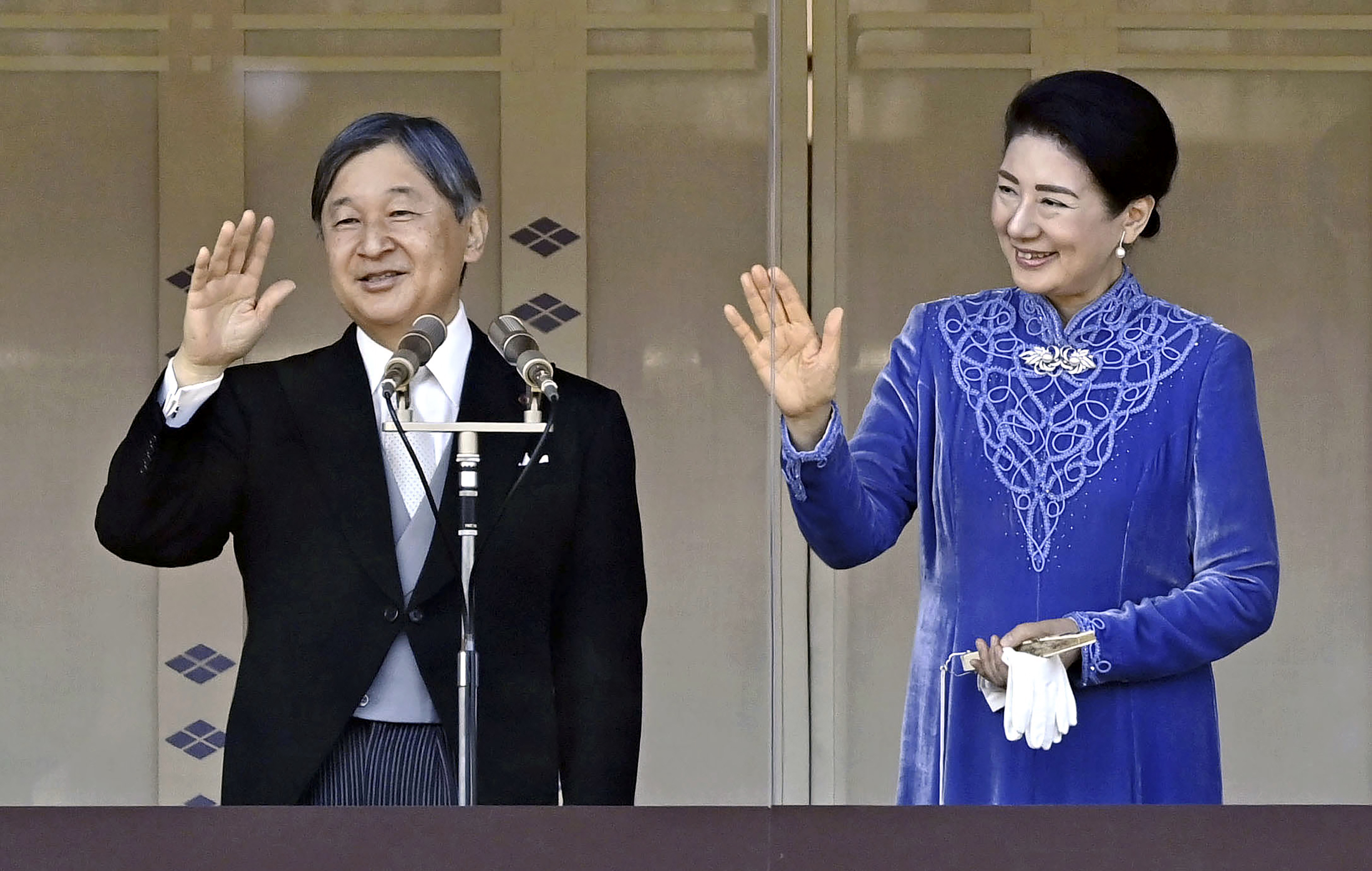 Japanese Emperor Naruhito, left, accompanied by Empress Masako, right, waves to well-wishers from the balcony of the Imperial Palace in Tokyo on his 65th birthday.