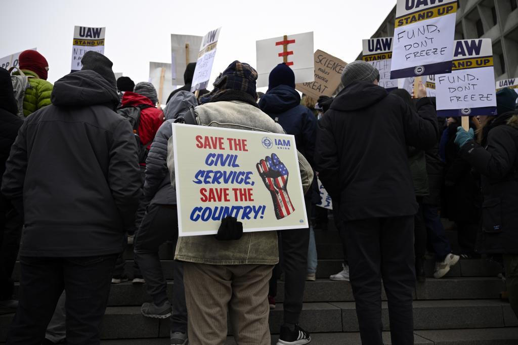 People rally to protest the polices of President Donald Trump and Elon Musk.