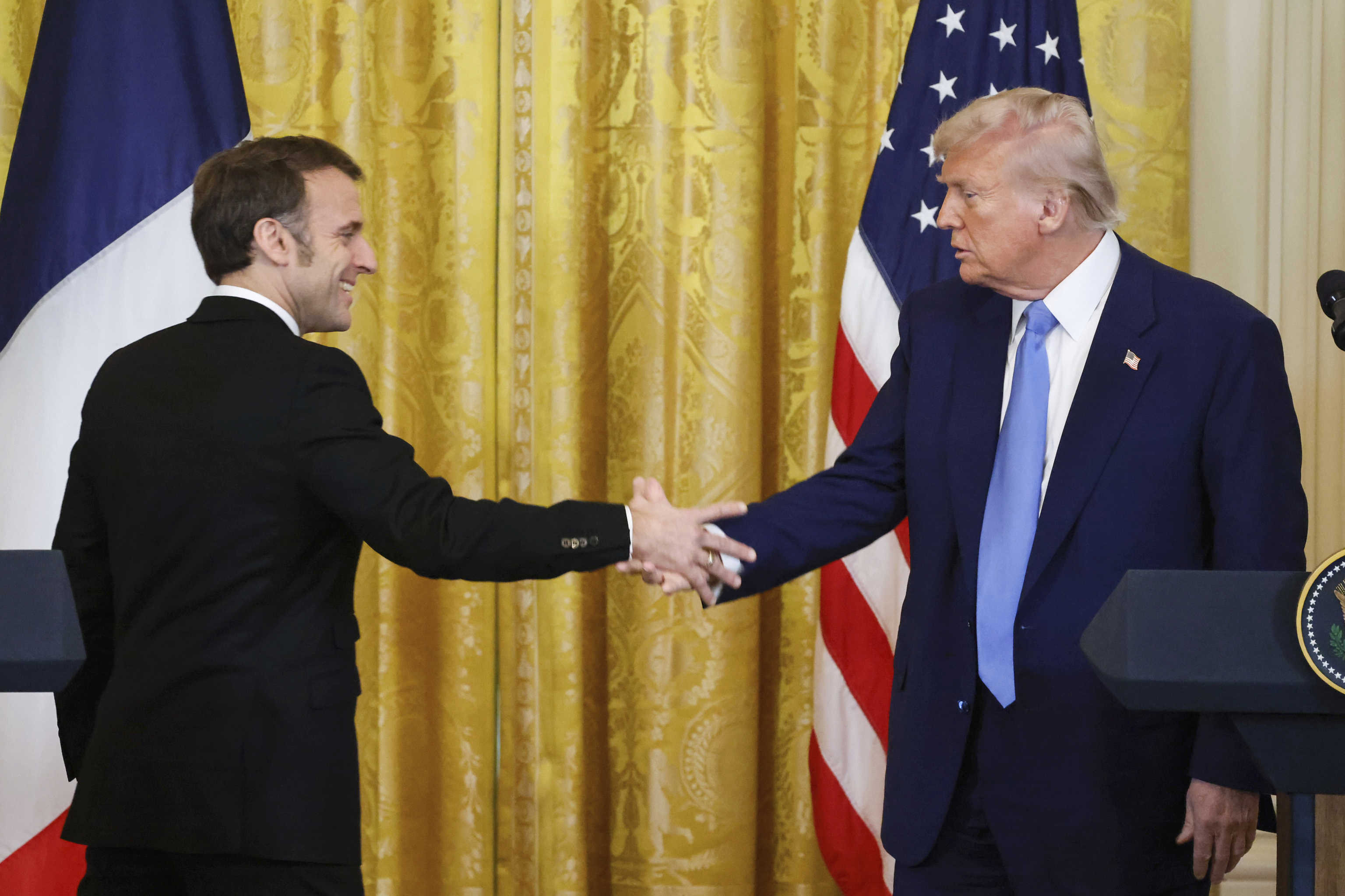 President Donald Trump, right, shakes the hand of France's President Emmanuel Macron.