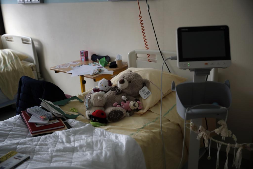 Teddy bears are placed on the bed of a child at the pediatric unit of the Robert Debre hospital, in Paris