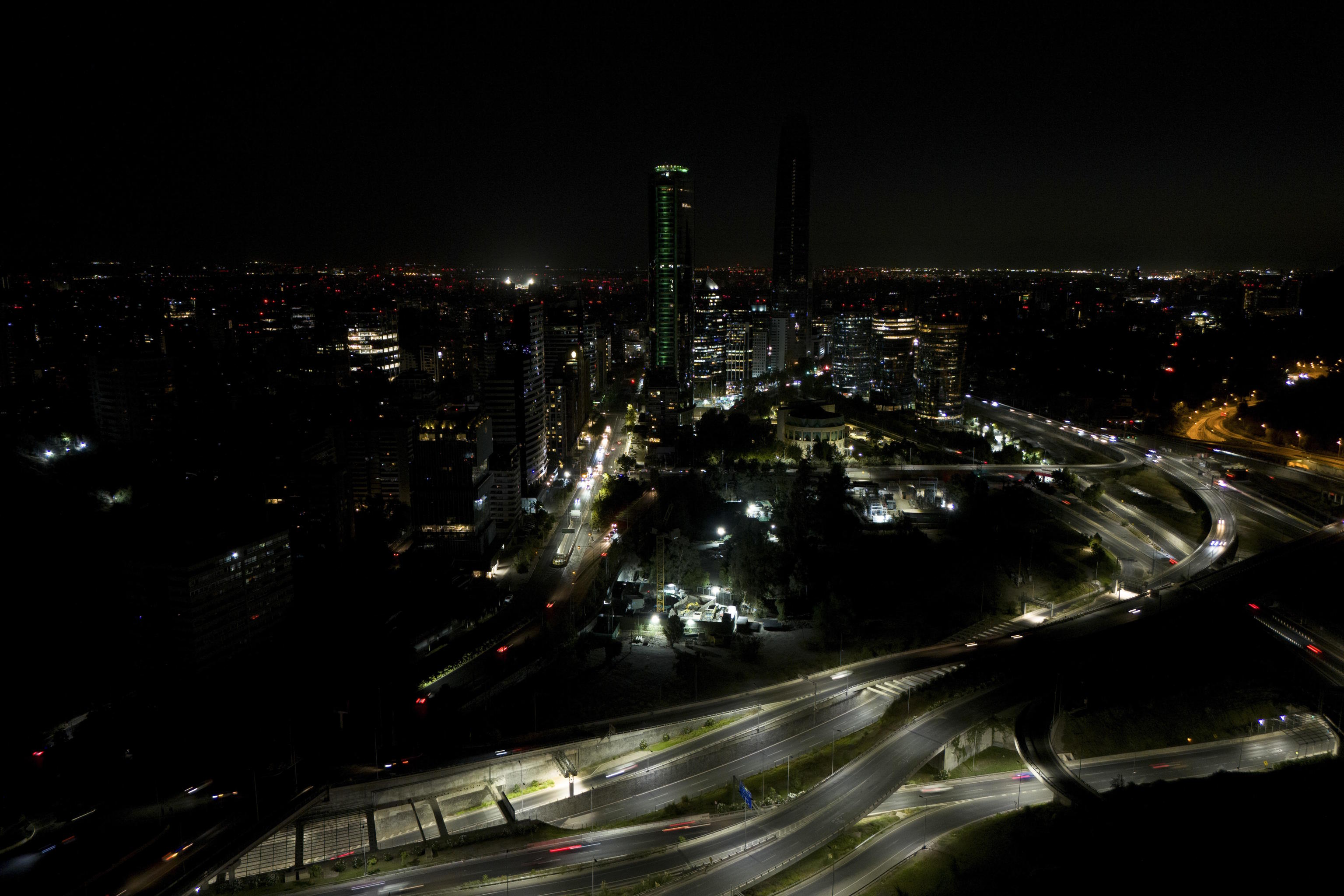 Cars zip past dark buildings during a power outage in Santiago, Chile.