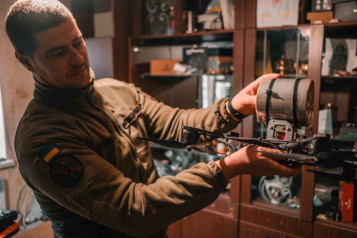 A Ukrainian commander holds a drone with an improvised explosive.