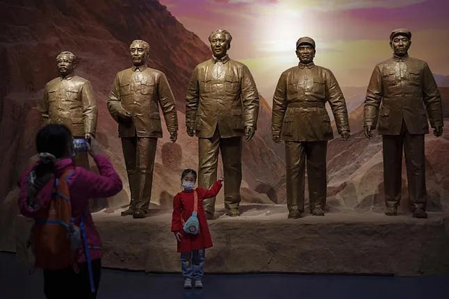 A mother takes a photo of her daughter while visiting the Museum of the Communist Party of China in Beijing this Sunday.