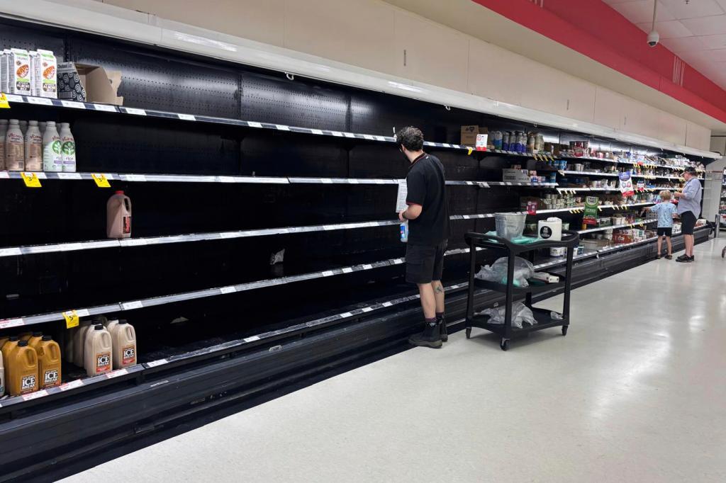 A worker cleans empty shelves at a supermarket in Brisbane, Australia