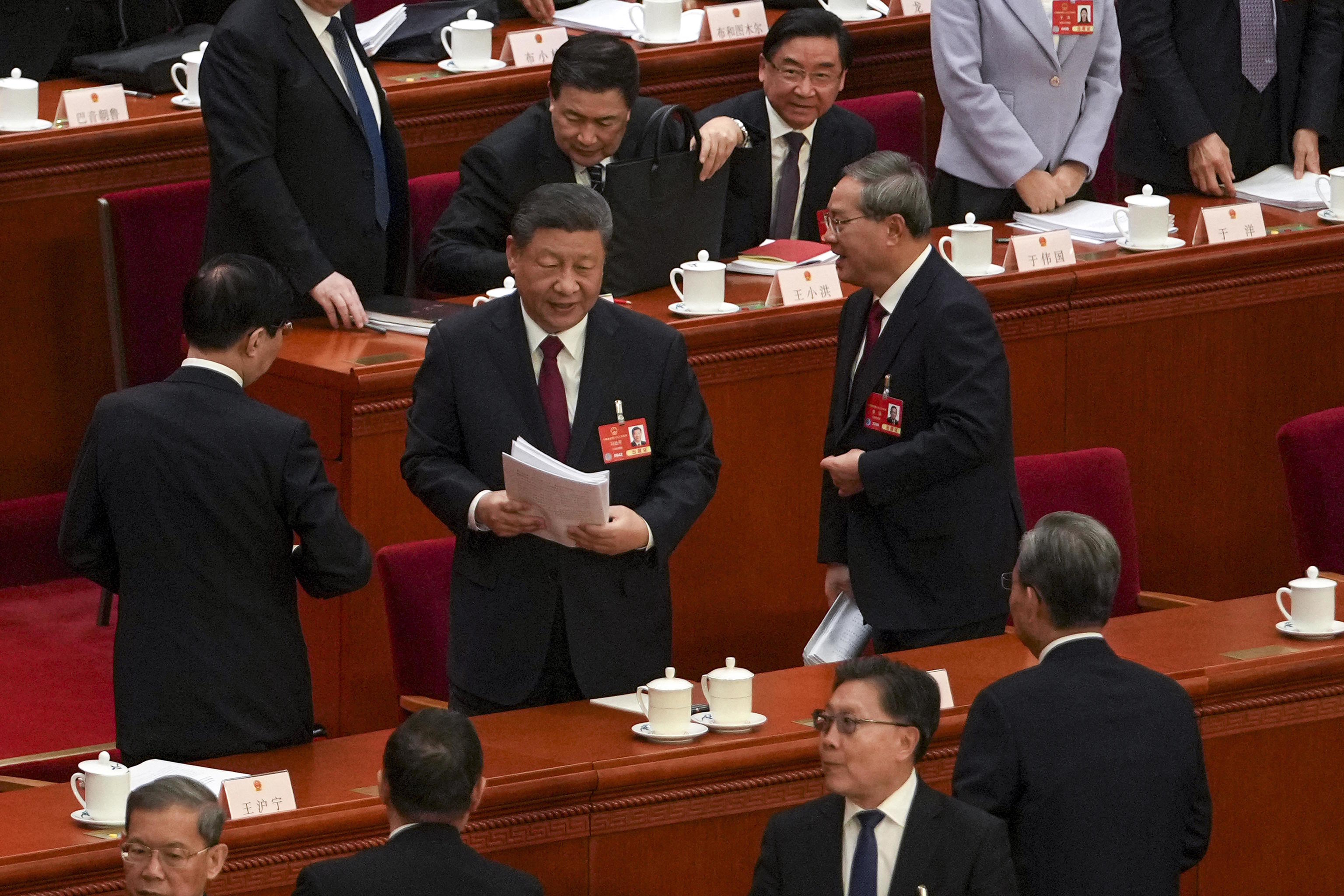 Chinese President Xi Jinping, center, and his Premier Li Qiang, left.