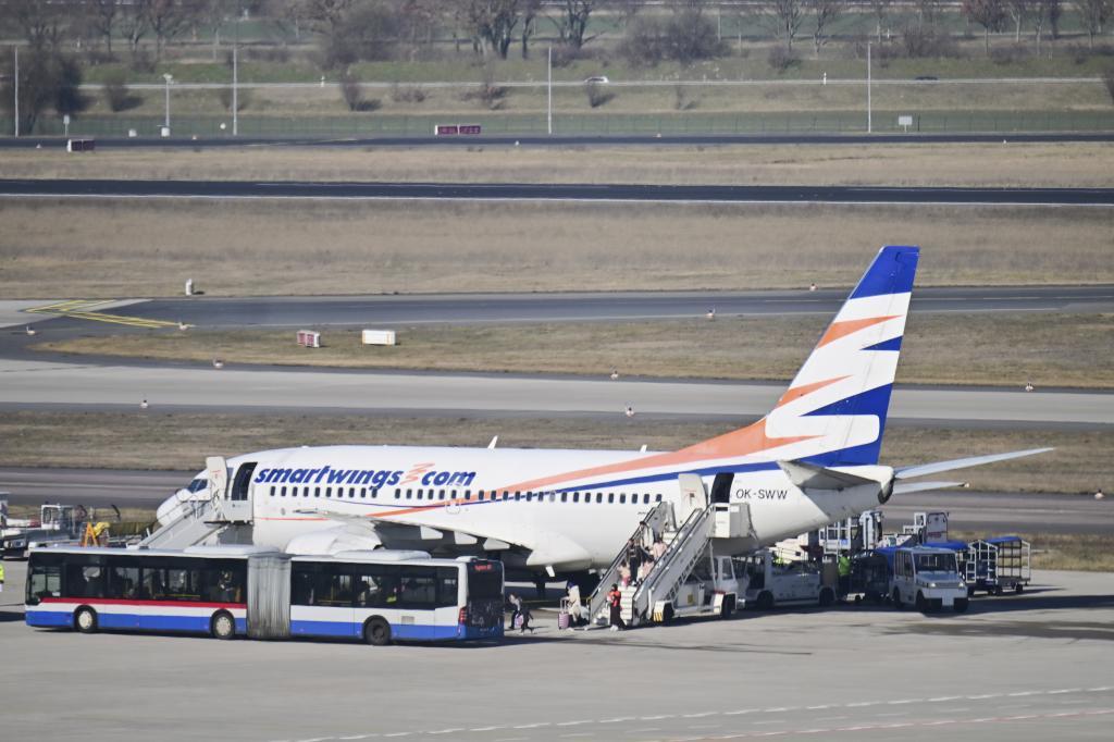 Passengers disembark from a plane carrying people from Afghanistan who have been granted asylum