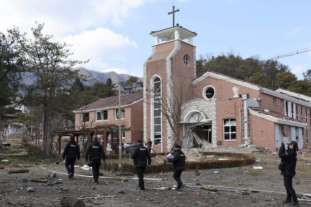 South Korean military investigators examine the site where a South Korean fighter jet accidentally dropped bombs on a civilian area