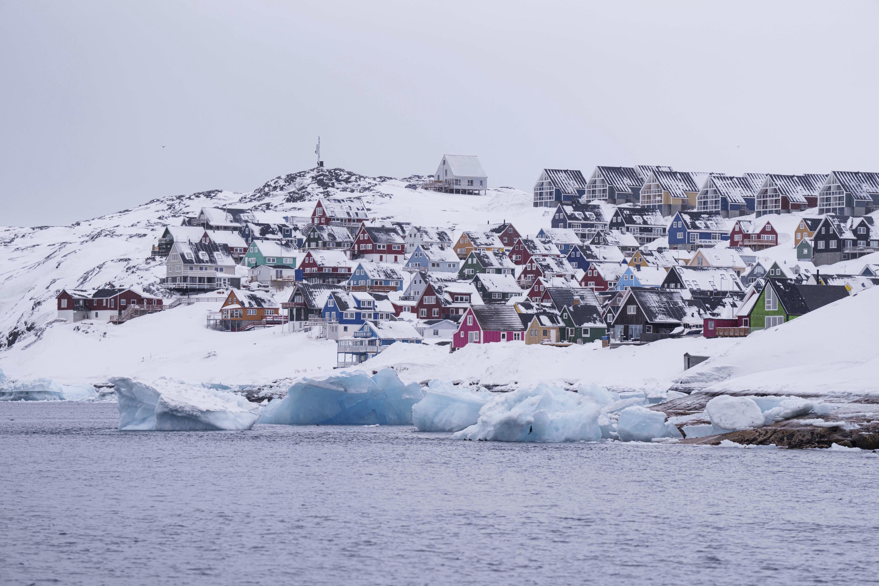 Coloured houses covered by snow are seen from the sea in Nuuk, Greenland.