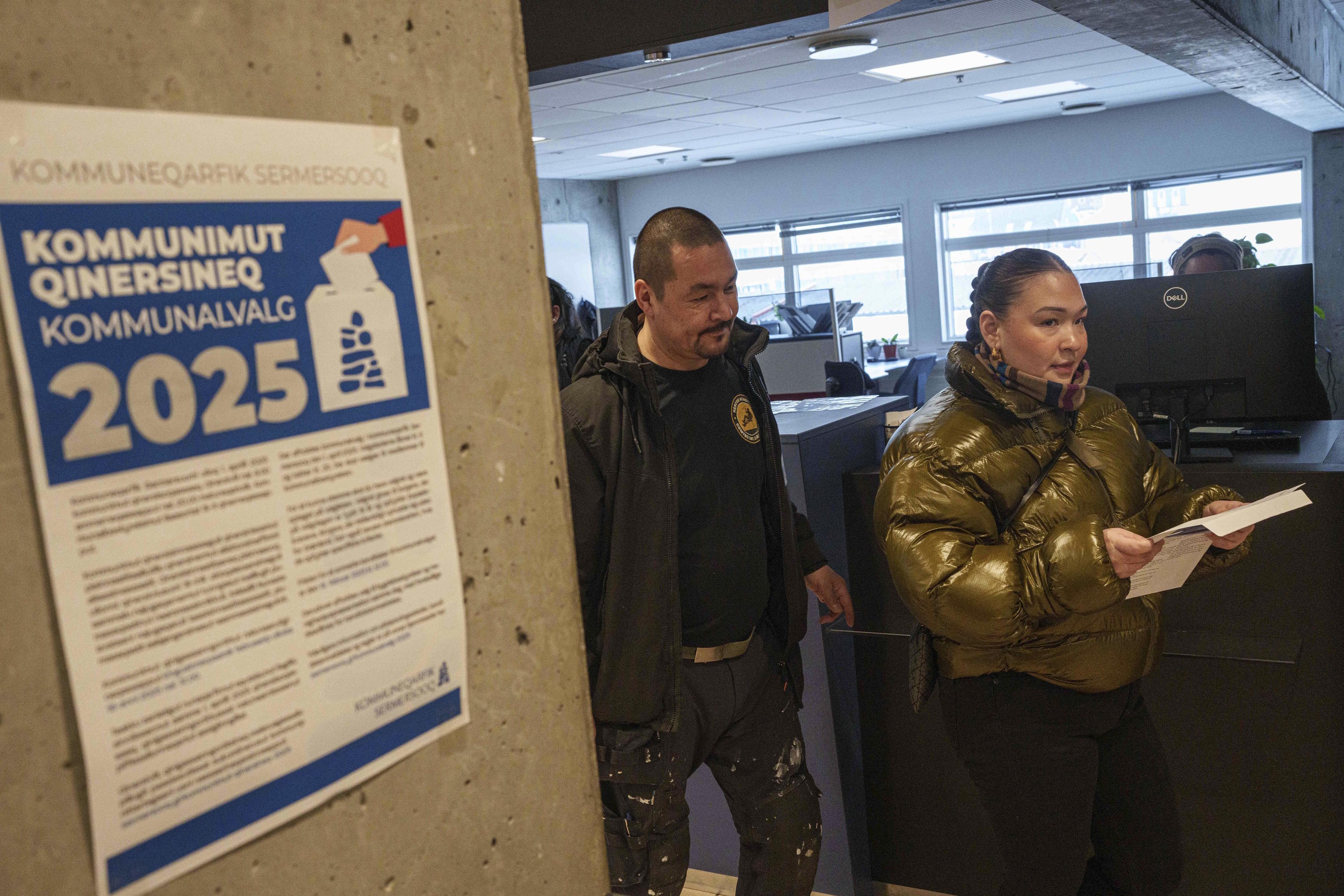 A woman carries her ballot during an early voting for Greenlandic parliamentary elections.