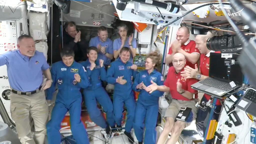 Astronauts greeting each other after a SpaceX capsule docked with the International Space Station