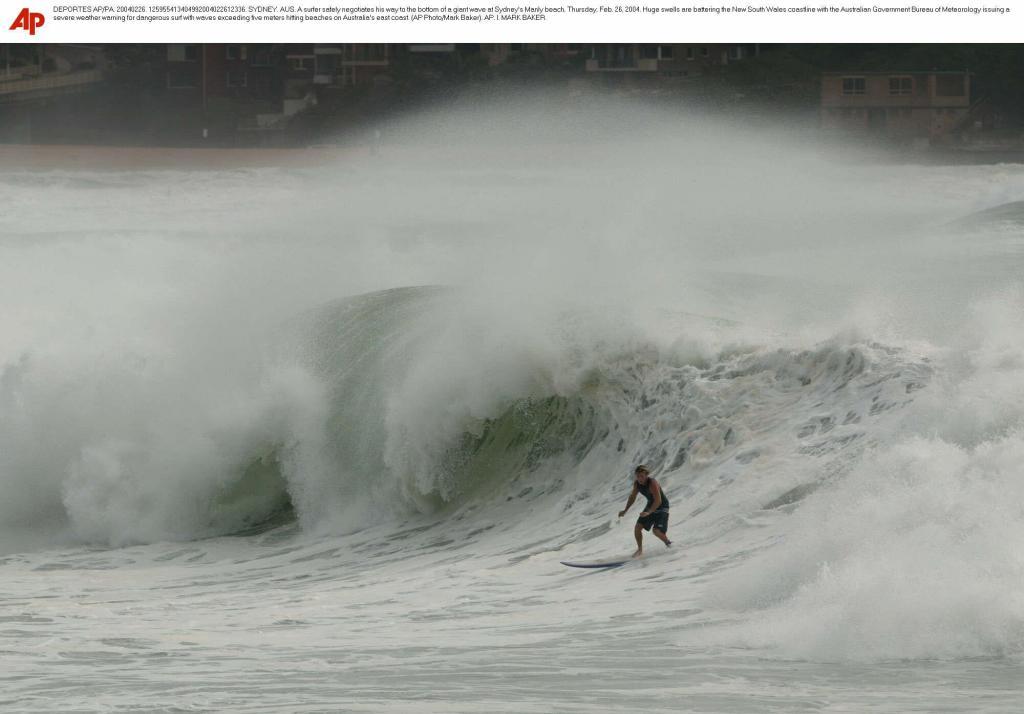 A surfer safely negotiates his way to the bottom of a giant wave at Sydney''s Manly beach