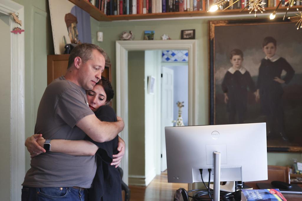 Jake Heinrichs hugs his wife, Rachel Chavkin, after speaking about early-stage Alzheimer's disease