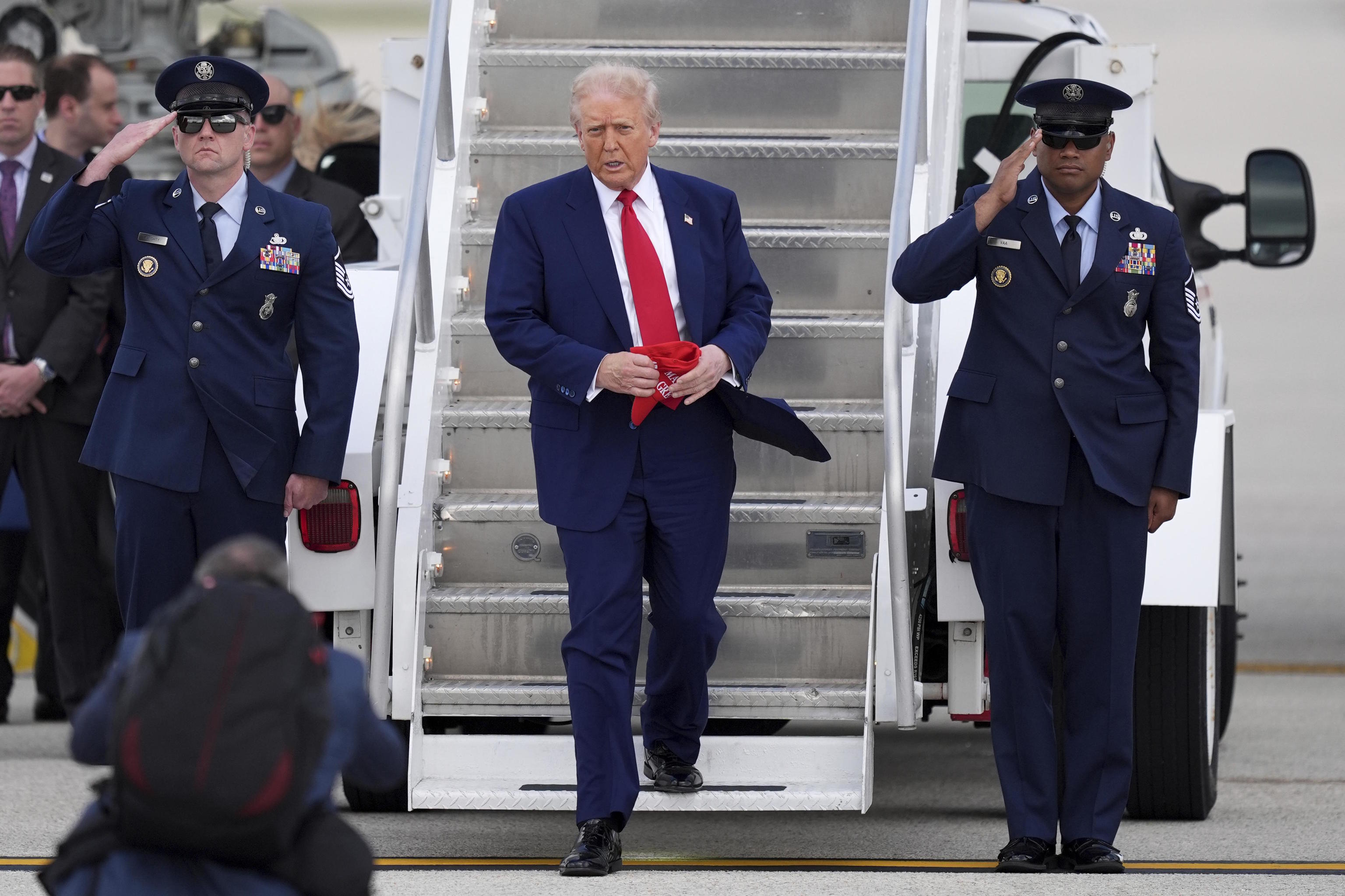 President Donald Trump, center, arrives on Air Force One.