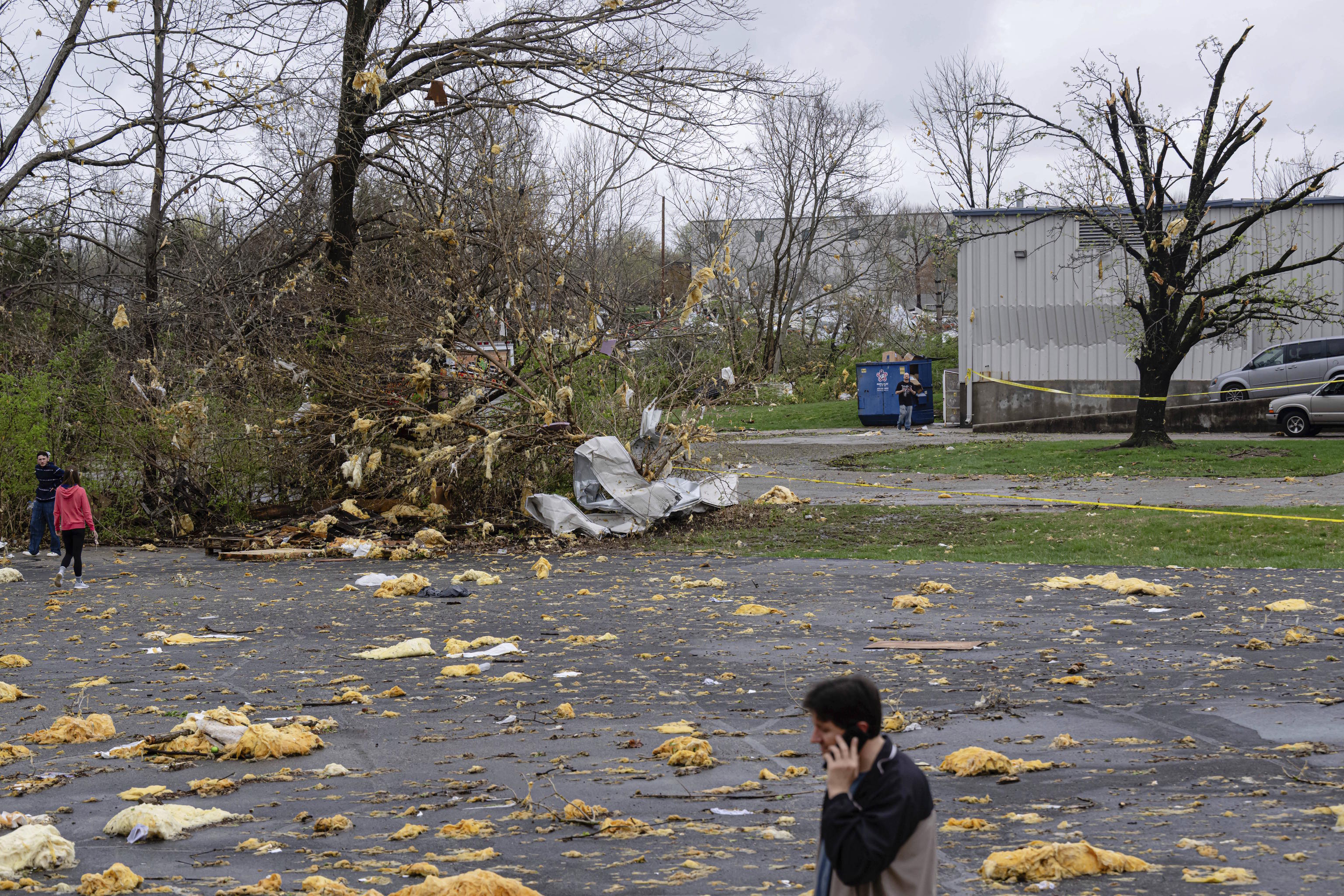 People walk through the debris field after a tornado passed through  in Jeffersontown.