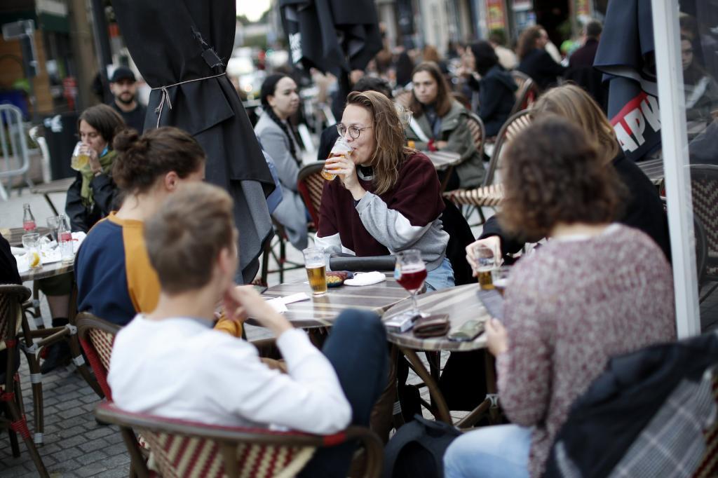 People drink beers on a terrace of a pub on the last evening for bars were closed in Brussels