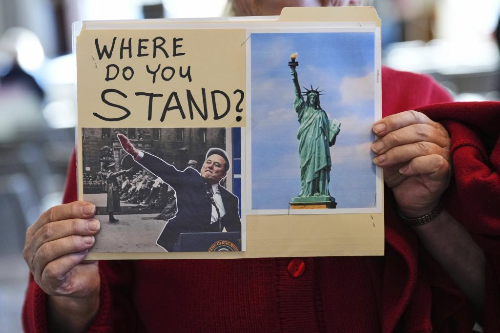 Linda Warren, of Winlock, Wash., holds up a sign showing Elon Musk