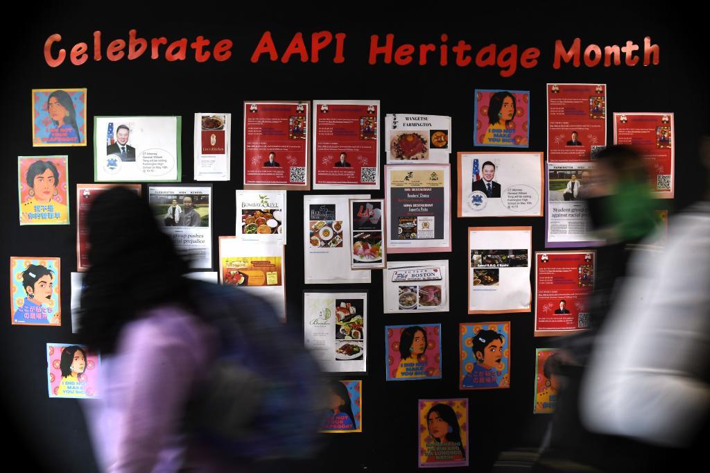 Students walk past a display for Asian Pacific American Heritage Month at Farmington High School
