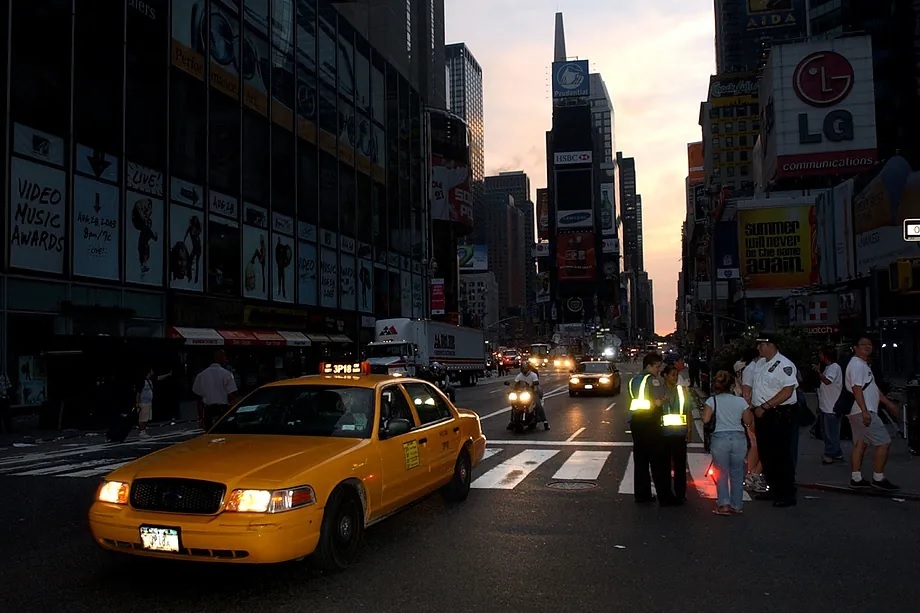 A yellow taxi drives down a dark street in New York in August 2003.