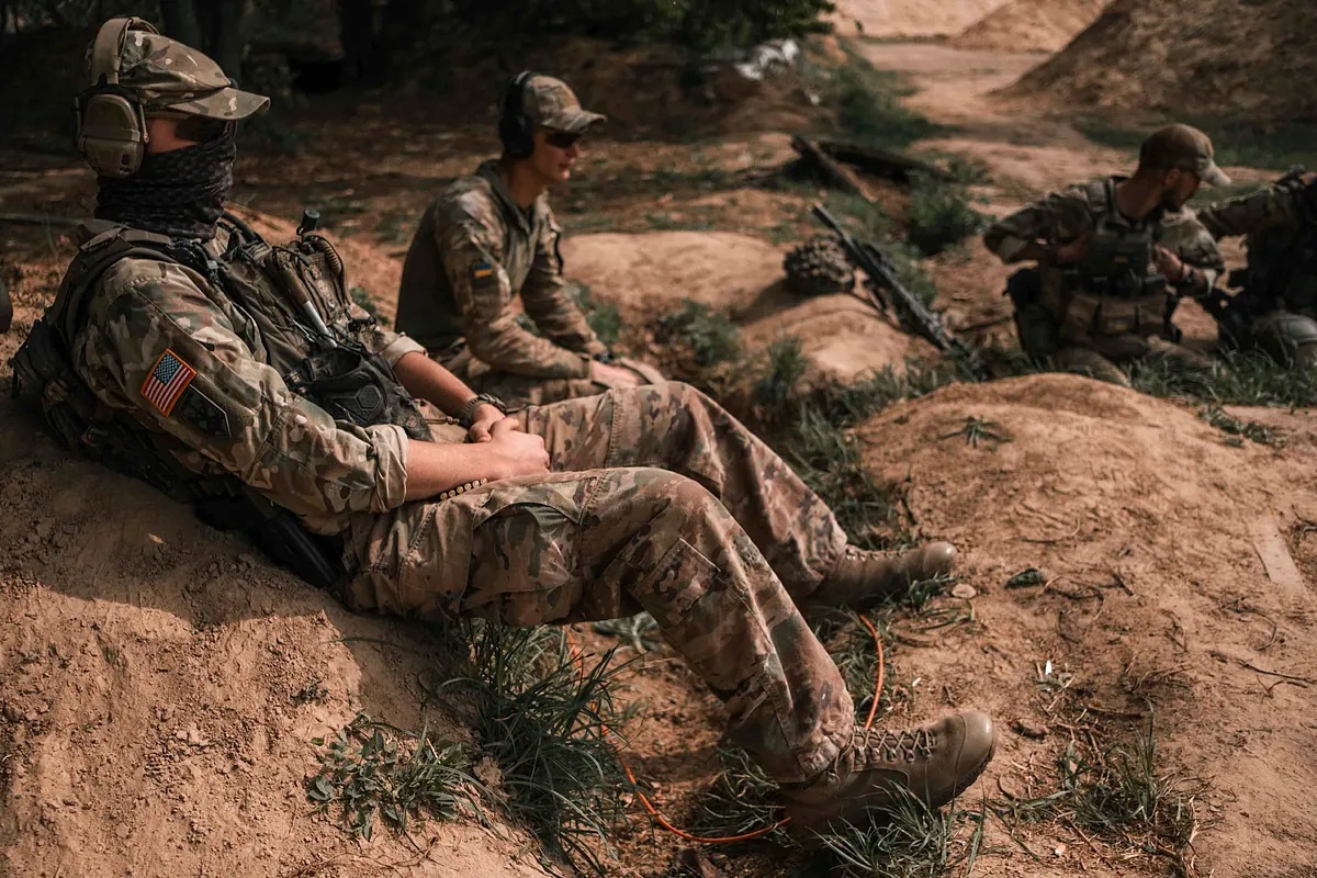 American volunteers rest while other comrades fire.