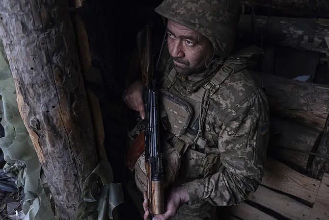 A Ukrainian soldier looks from a shelter at the anti-drone shooting position.