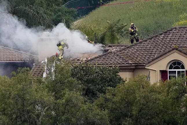 Firefighters in the residential area where the small plane crashed.