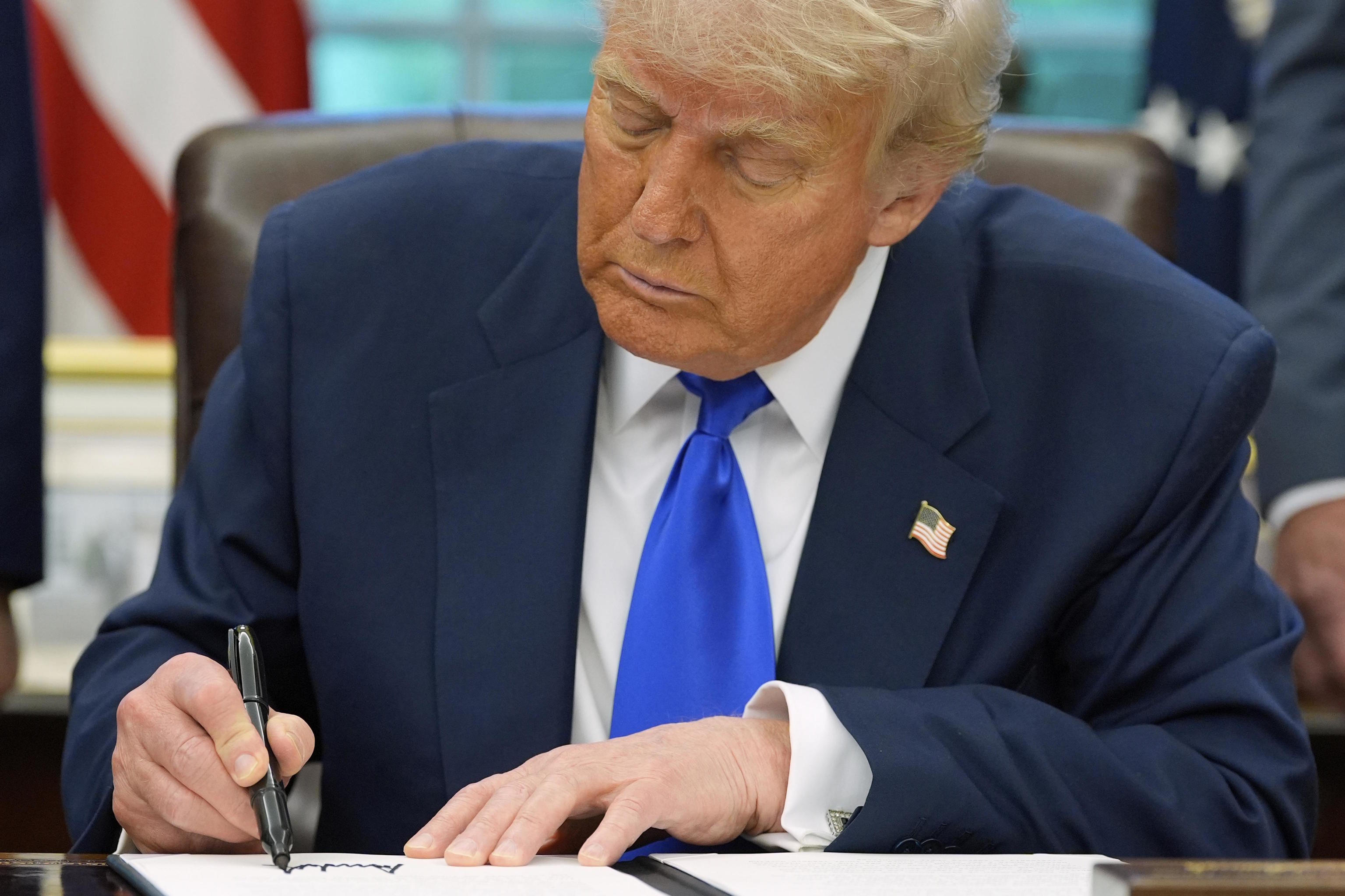 President Donald Trump signs executive orders.