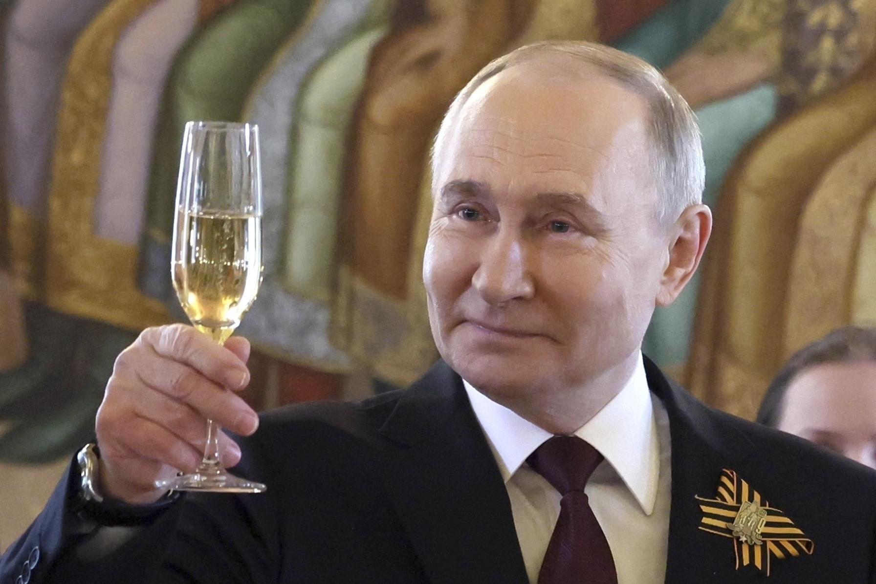 Russian President Vladimir Putin raises a Victory Day toast celebrating.