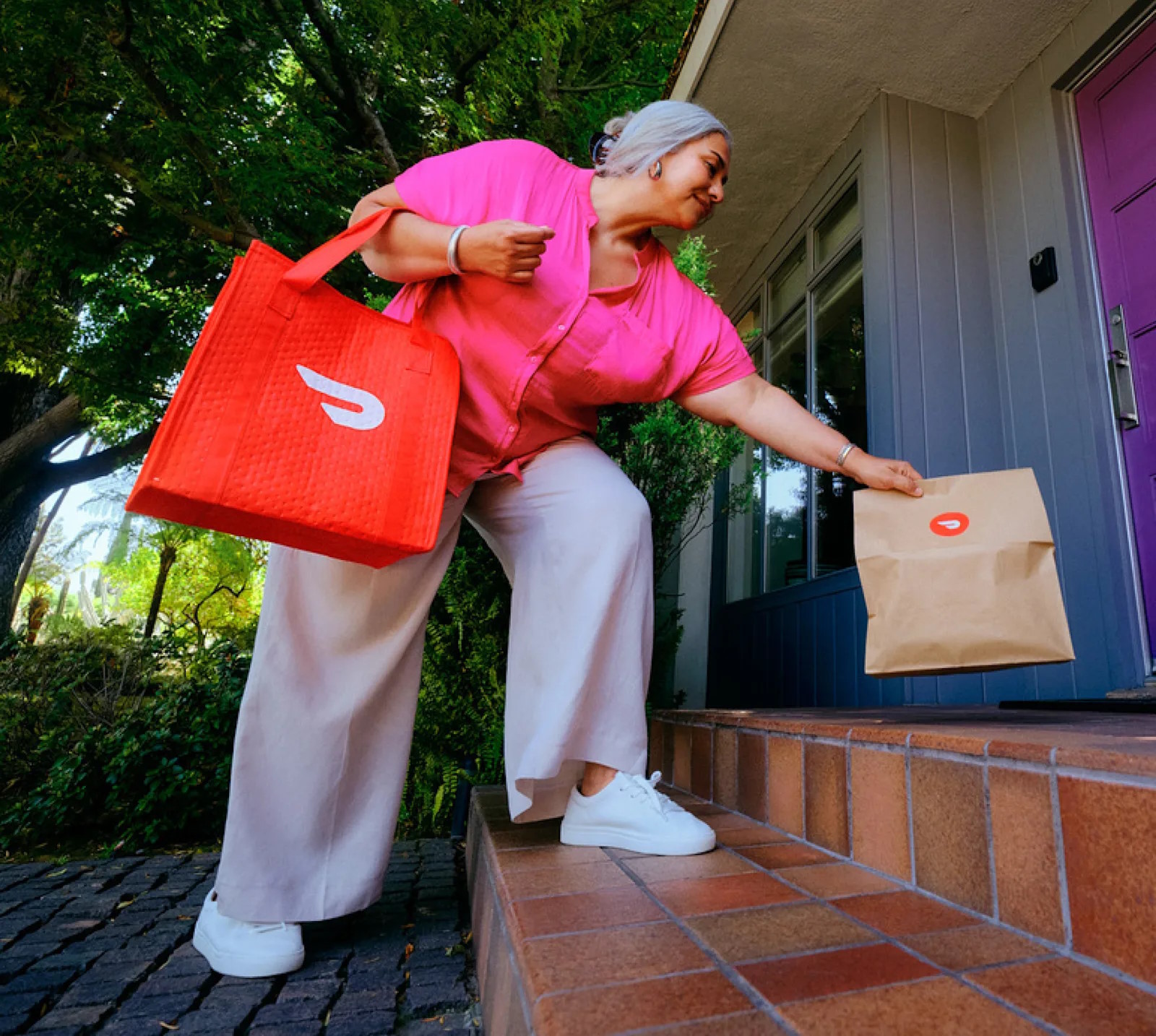 An employee leaves an order on a customer's doorstep.