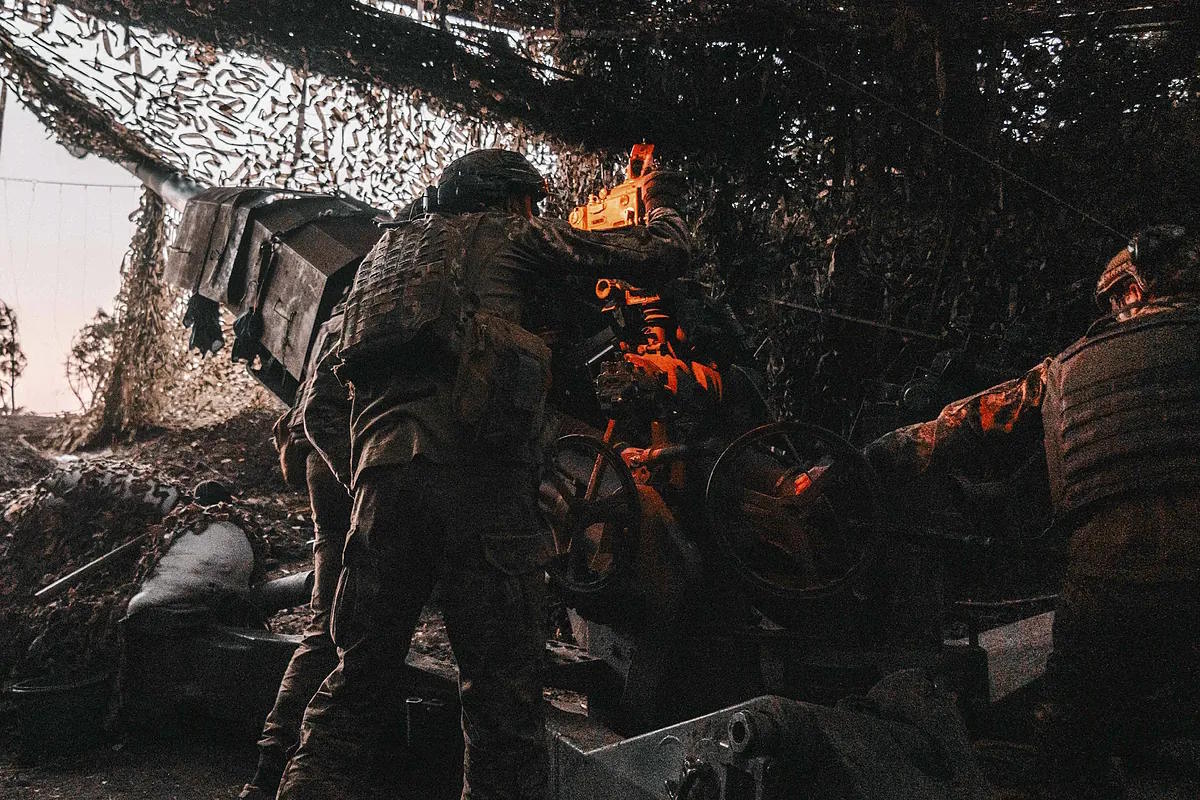 Ukrainian soldiers aim the cannon at Russian positions before firing the projectile.