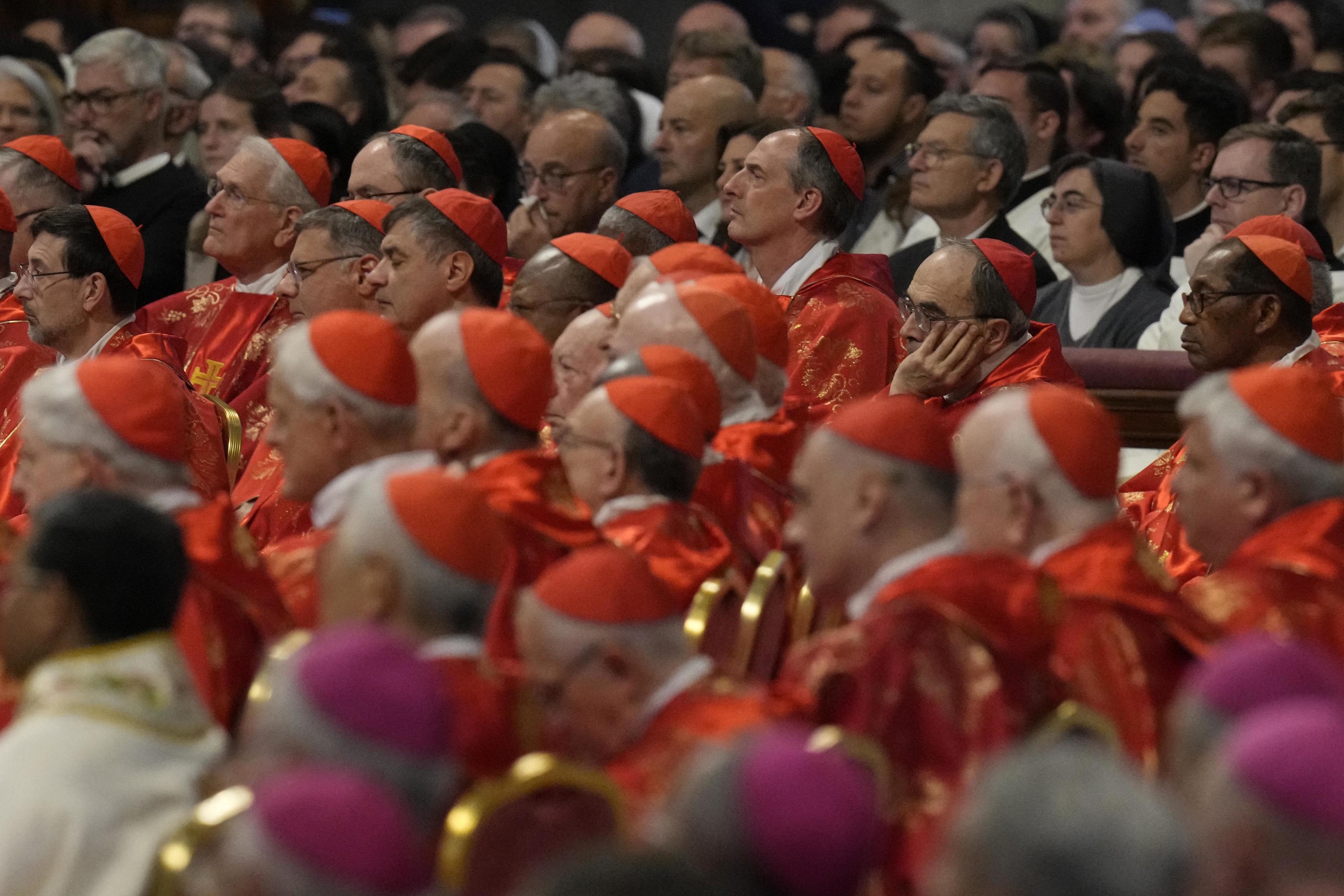 Cardinals, in red beretta hats, attend a final Mass celebrated by cardinals inside St. Peter's Basilica.