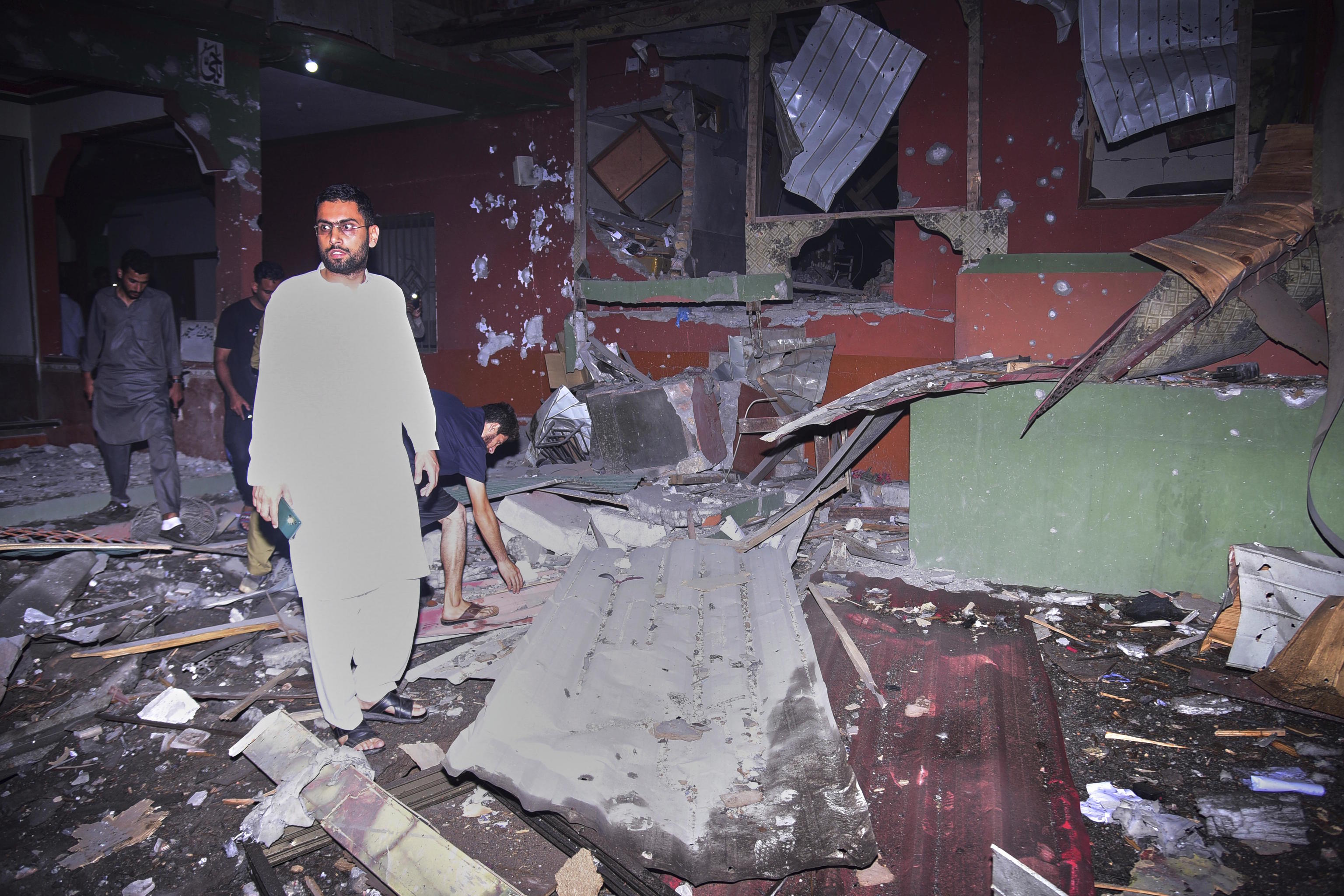 Residents check the damage to a building caused by a suspected Indian missile attack.