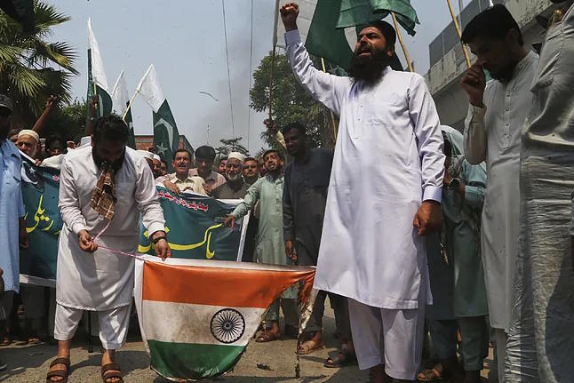 Supporters of the Central Muslim League party burn an Indian flag in Peshawar this Wednesday.