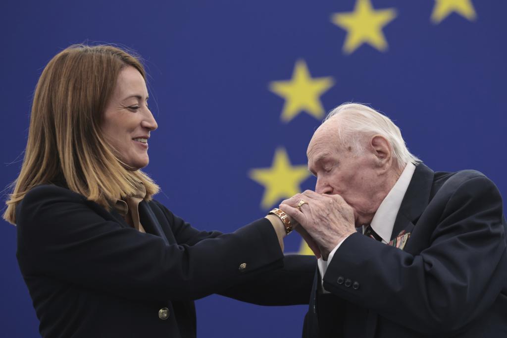 President of the Association of Home Army Soldiers Janusz Komorowski ,of Poland, kisses European Parliament President Roberta Metsola's hand