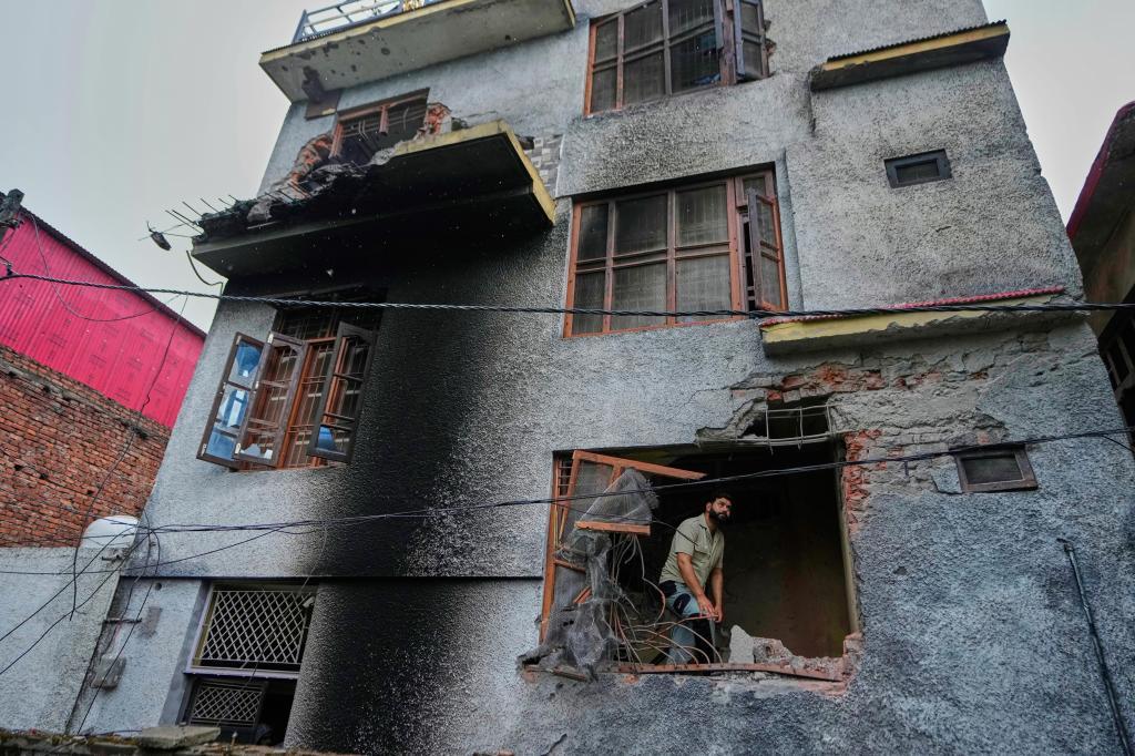 A resident inspects his house damaged by Pakistani artillery shelling in Poonch,