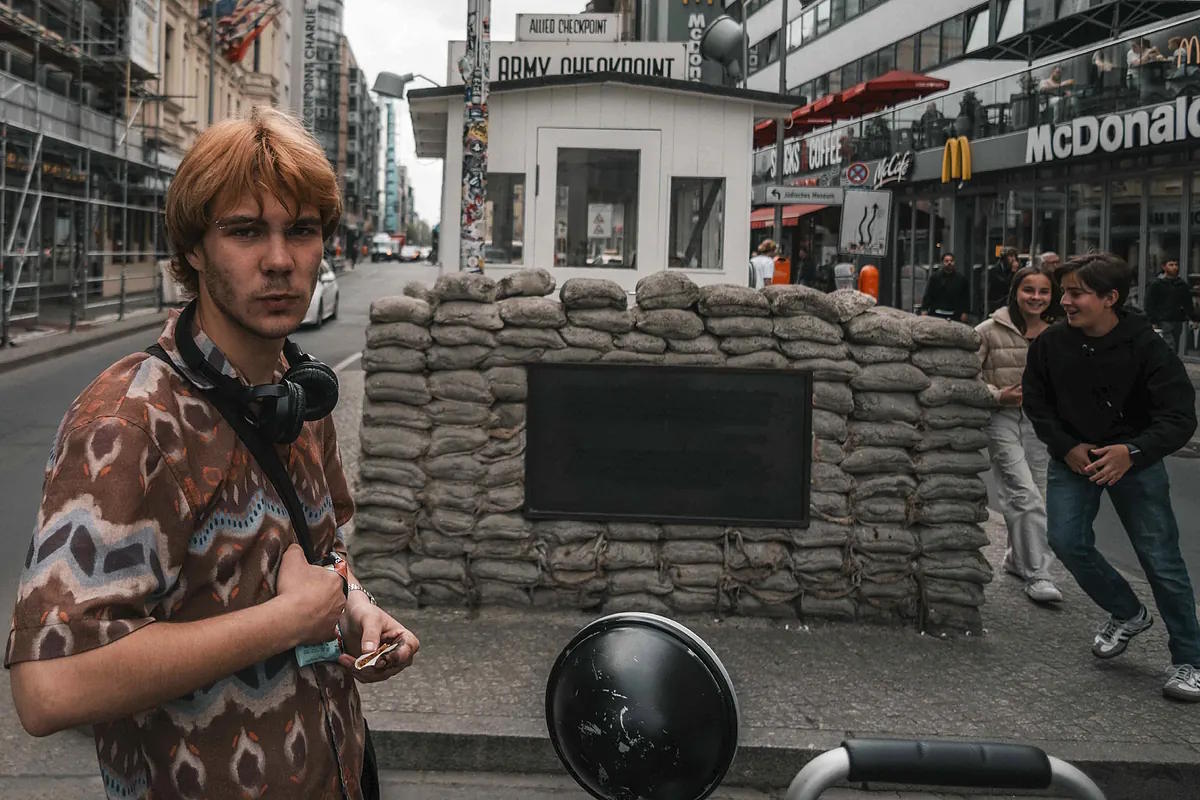 A young man poses in front of Checkpoint Charlie, the most famous of the Berlin Wall border crossings.