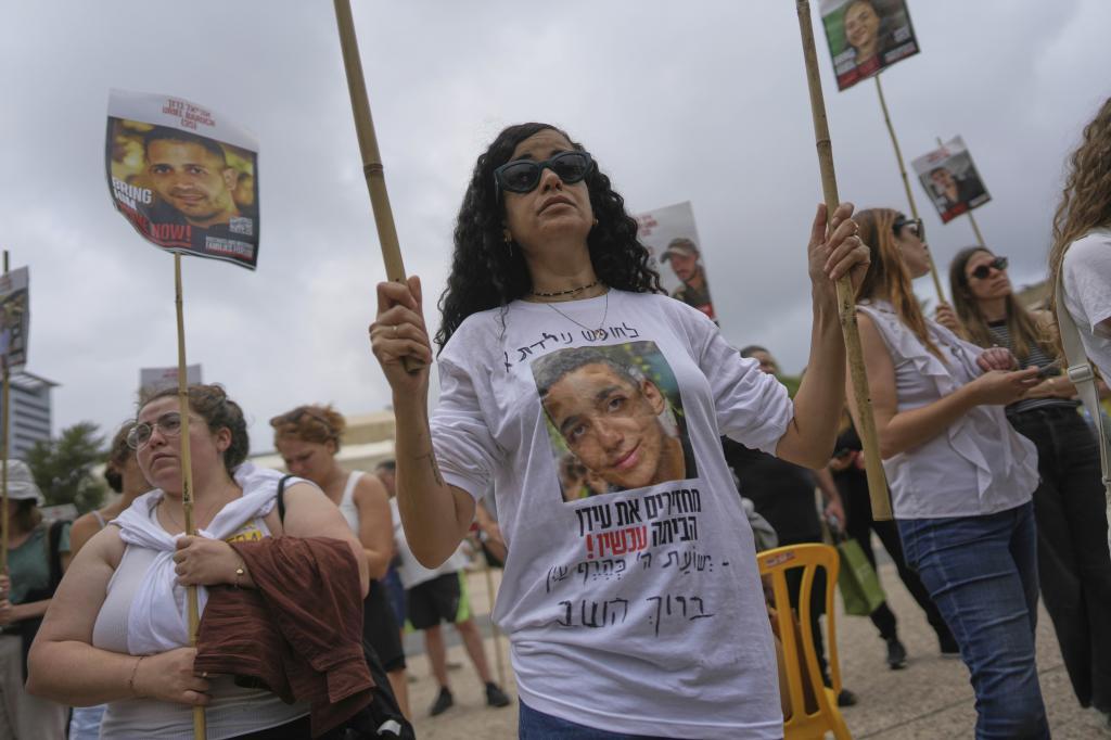 An Israeli woman wears a t-shirt with the photograph of Israeli-American soldier Edan Alexander