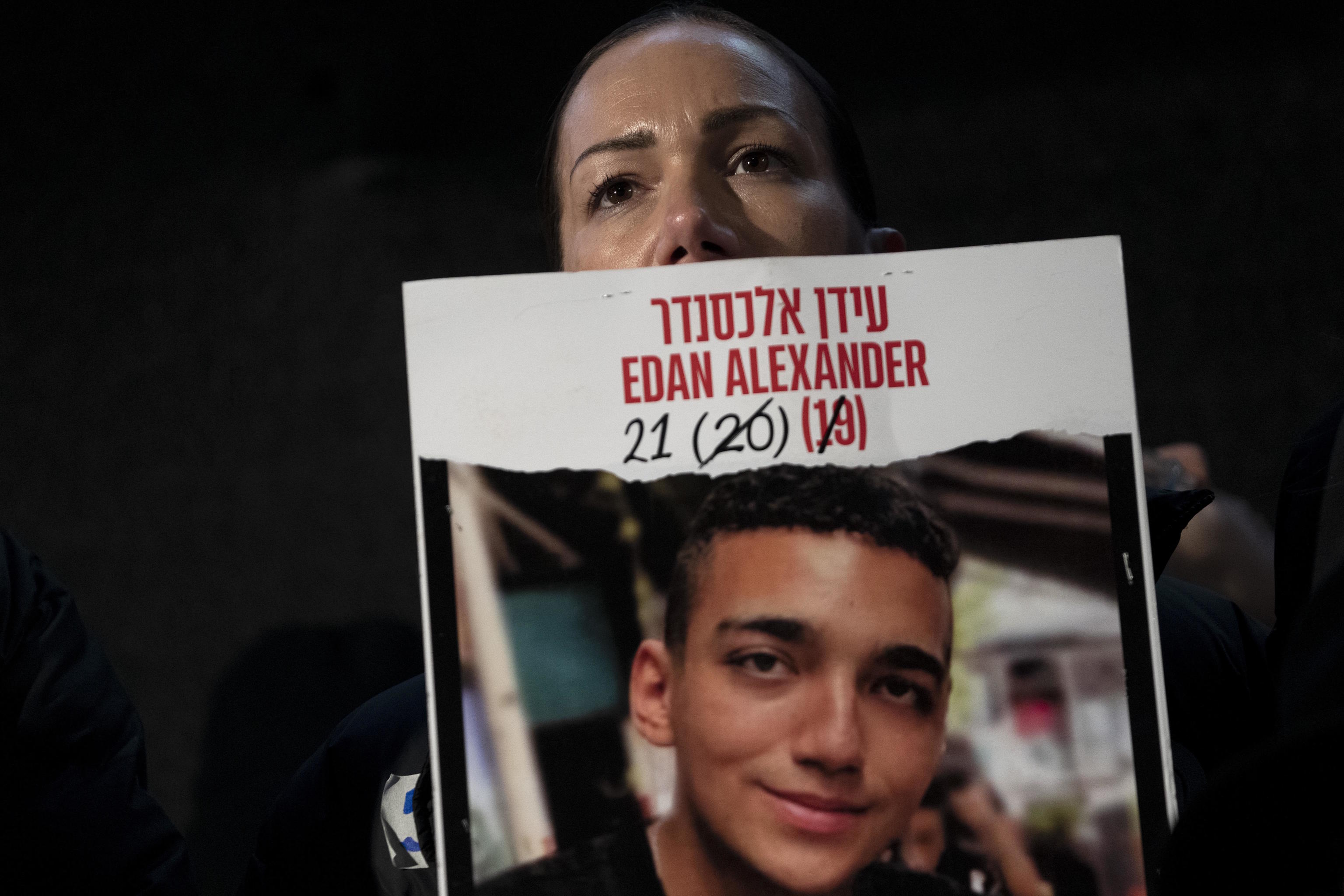 Yael Alexander shows a poster of her son, Edan.