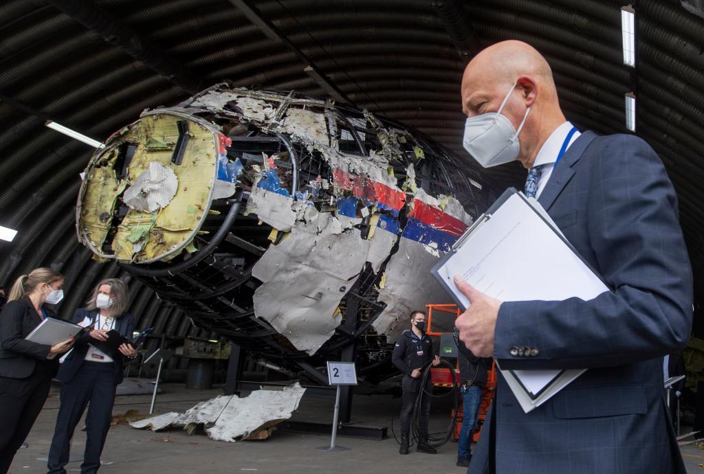 Presiding judge Hendrik Steenhuis, right, other trial judges and lawyers view the reconstructed wreckage of Malaysia Airlines Flight MH17