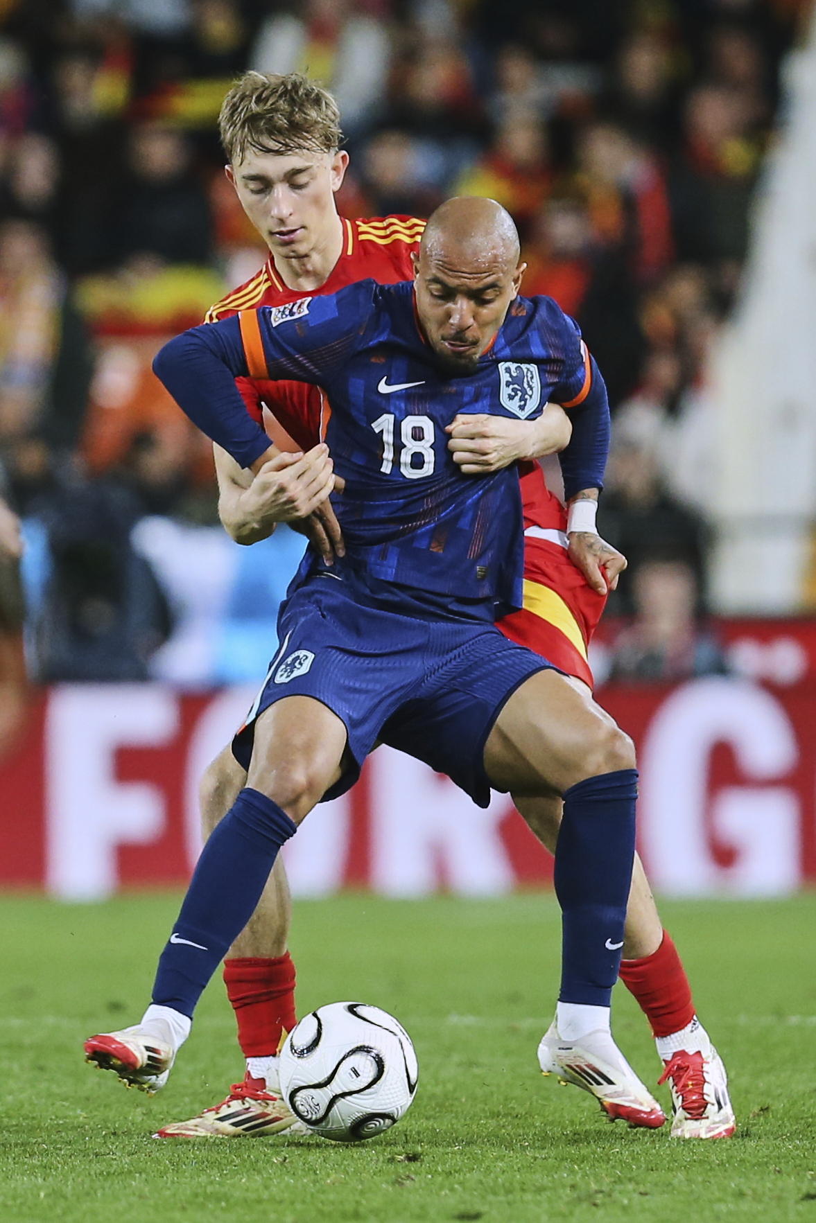 Spain's Dean Huijsen, background, duels for the ball with Netherlands' Donyell Malen.