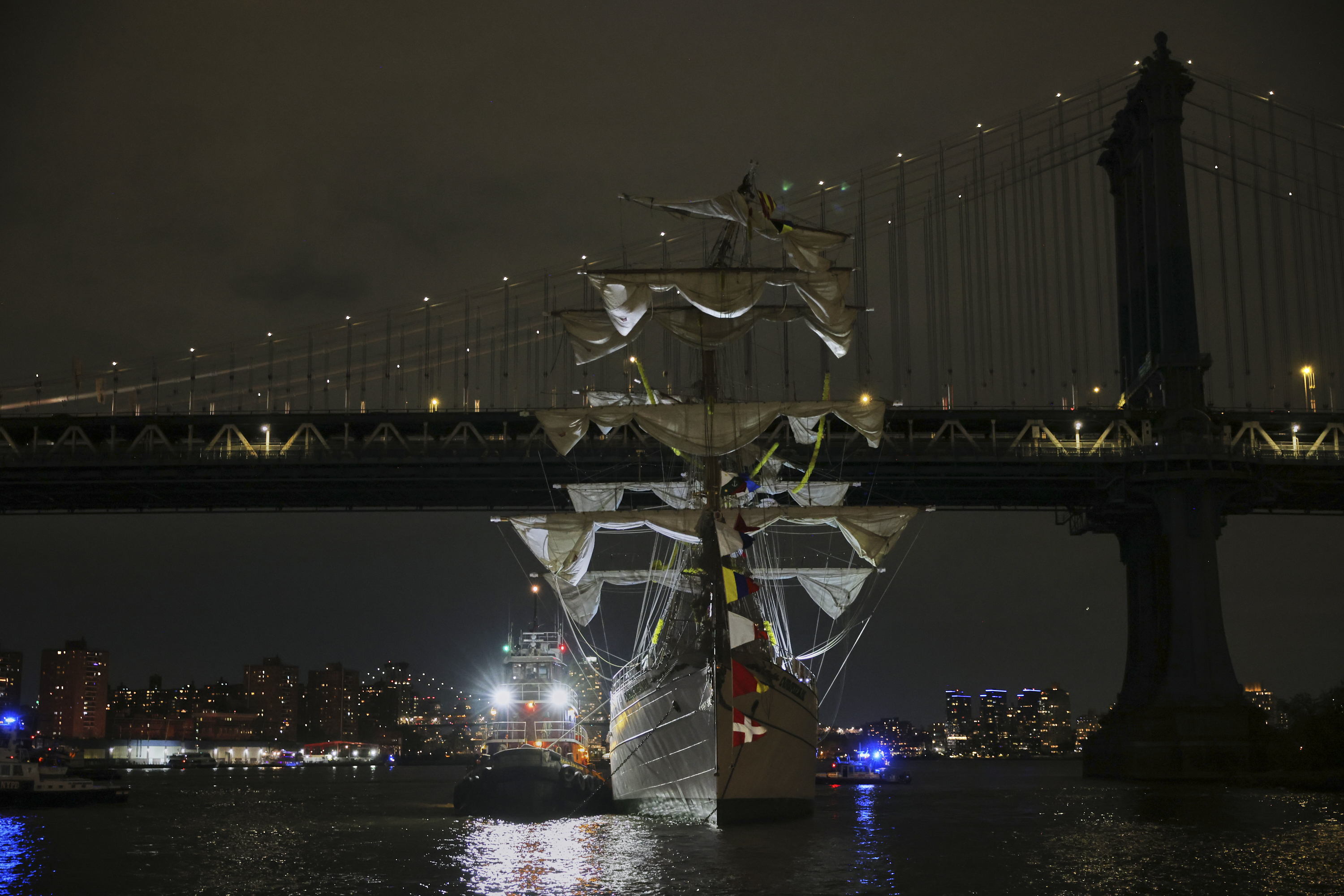 A tug boat helps stabilize the Cuauhtmoc, a masted Mexican Navy training ship as it sits stranded near the Manhattan Bridge after colliding with the Brooklyn Bridge.