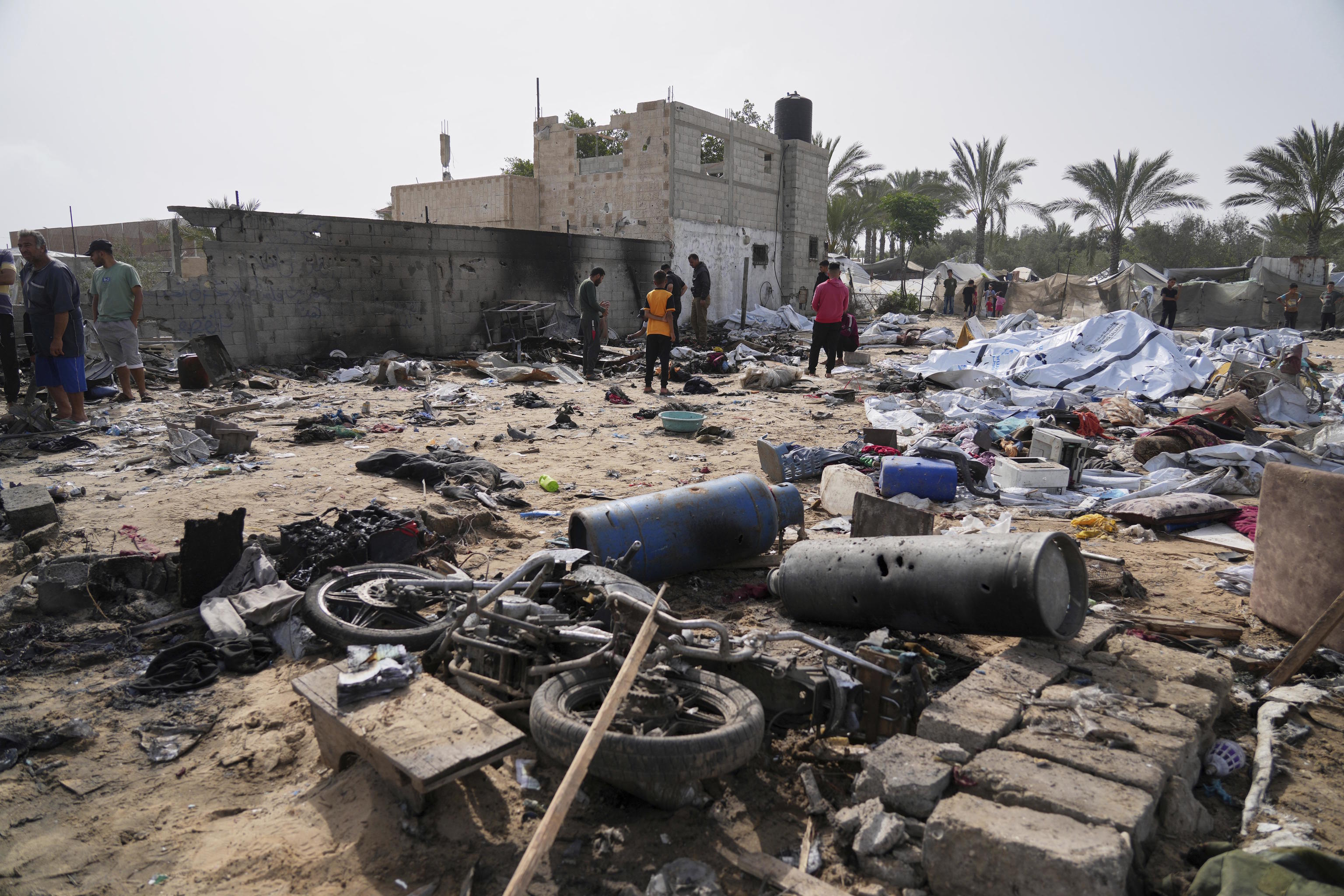 Palestinians inspect an area destroyed by Israeli airstrikes in Khan Yunis.