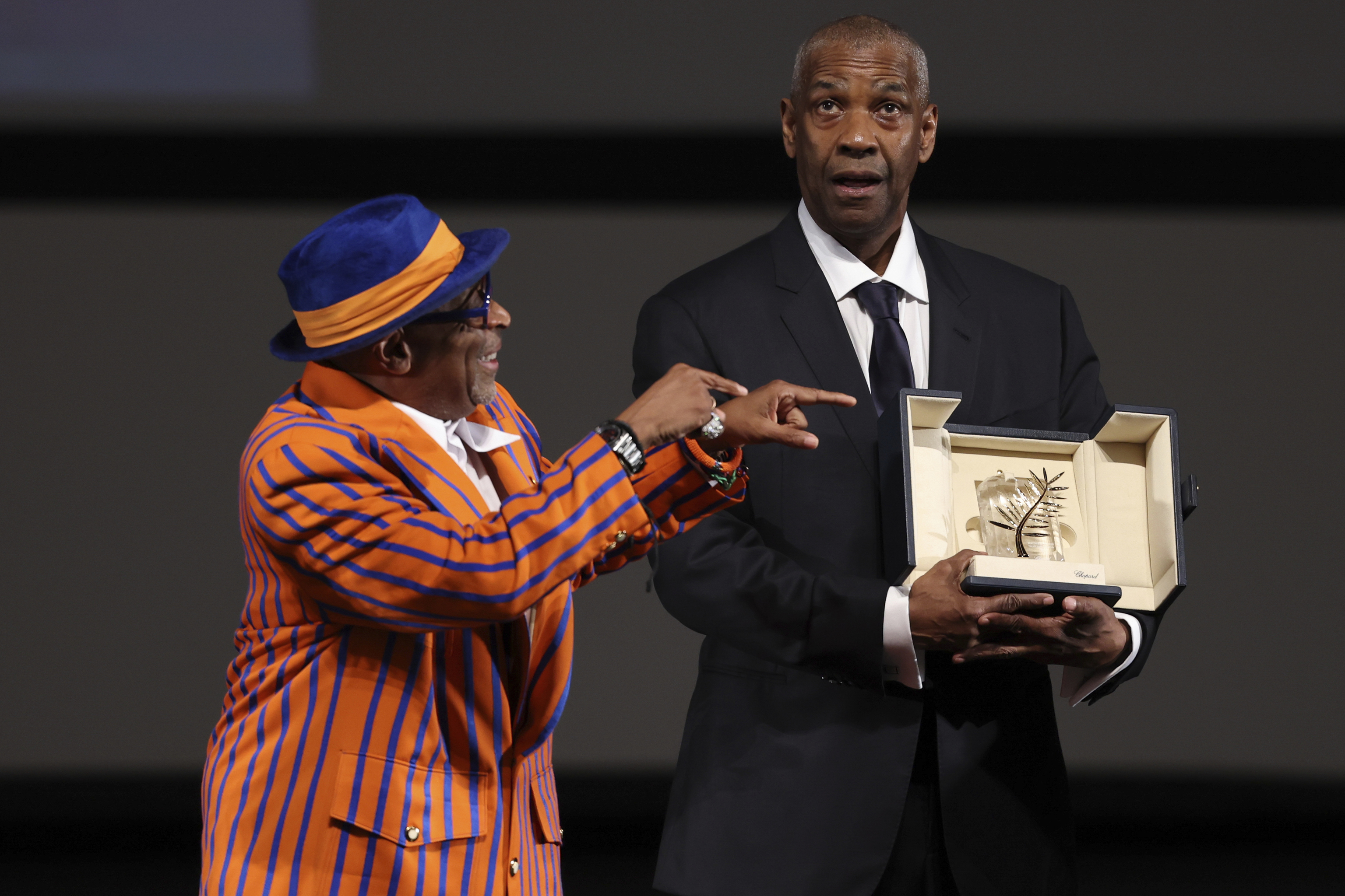 Actor Denzel Washington receives an Honorary Palme d'Or (Golden Palm) from director Spike Lee, left.