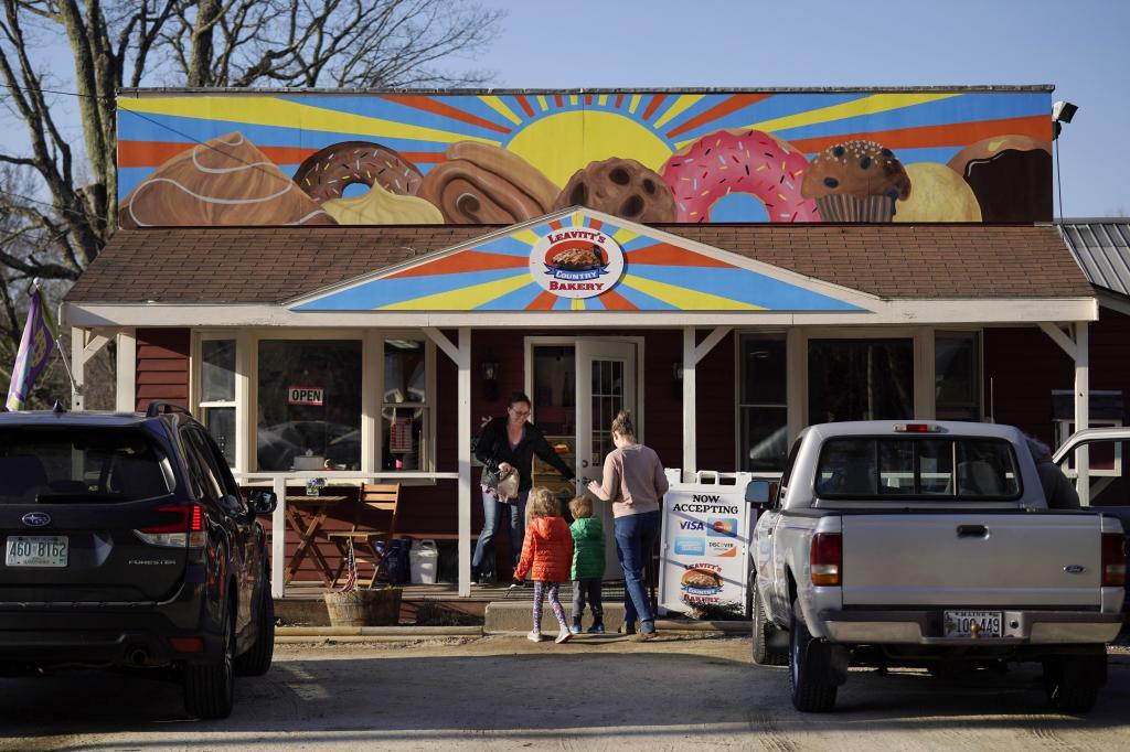 A customer holds the door for a family arriving at Leavitt's Country Bakery