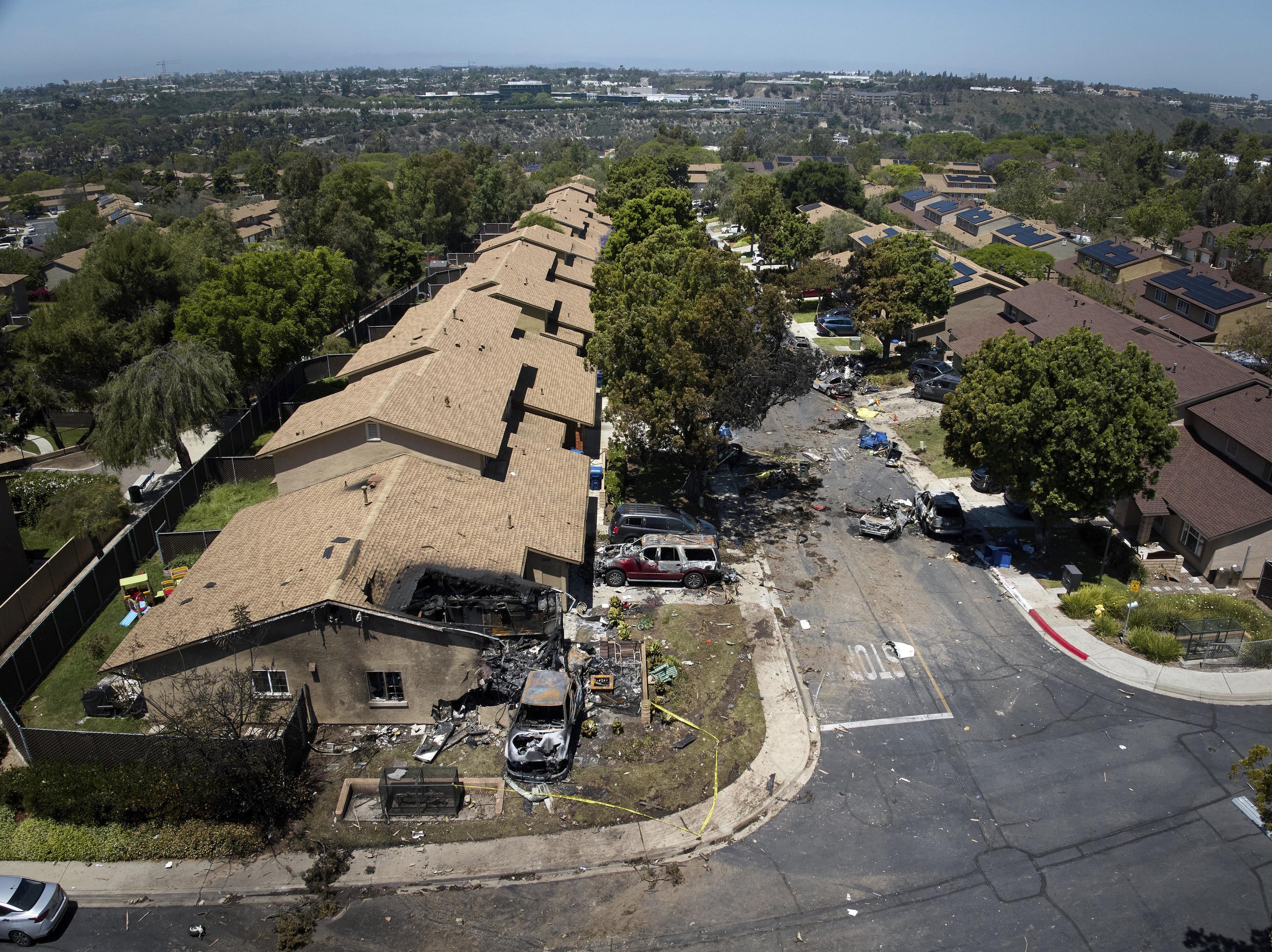 Debris covers the ground after a small plane crashed into a San Diego.