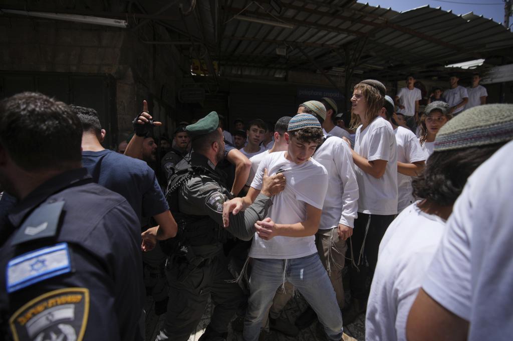 Israeli youths argue with police during a march marking Jerusalem Day
