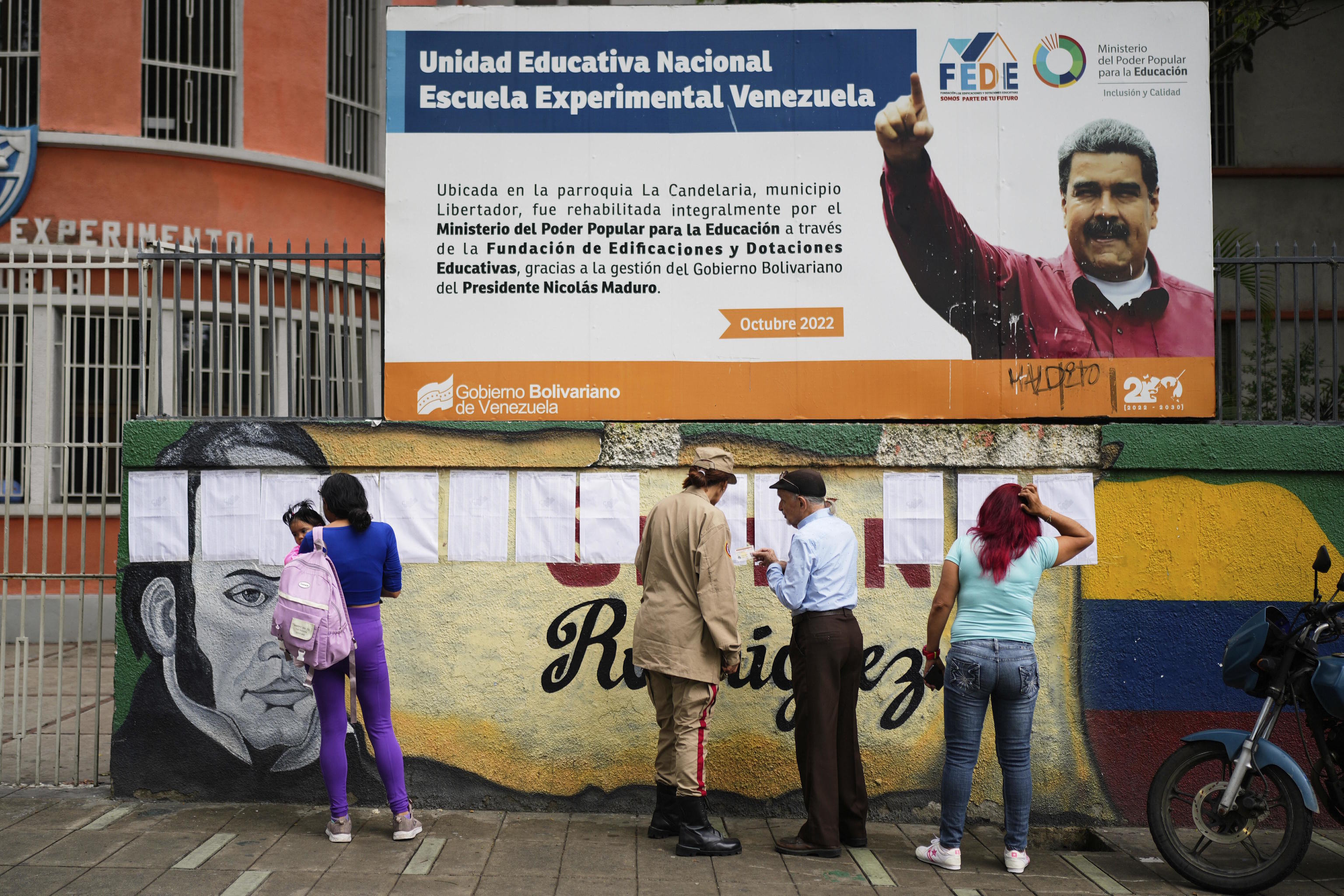 Voters look at voter lists at a polling station during the elections in Caracas.