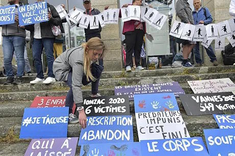 People put up signs during a demonstration before the verdict in the trial of Joel Le Scouarnec.