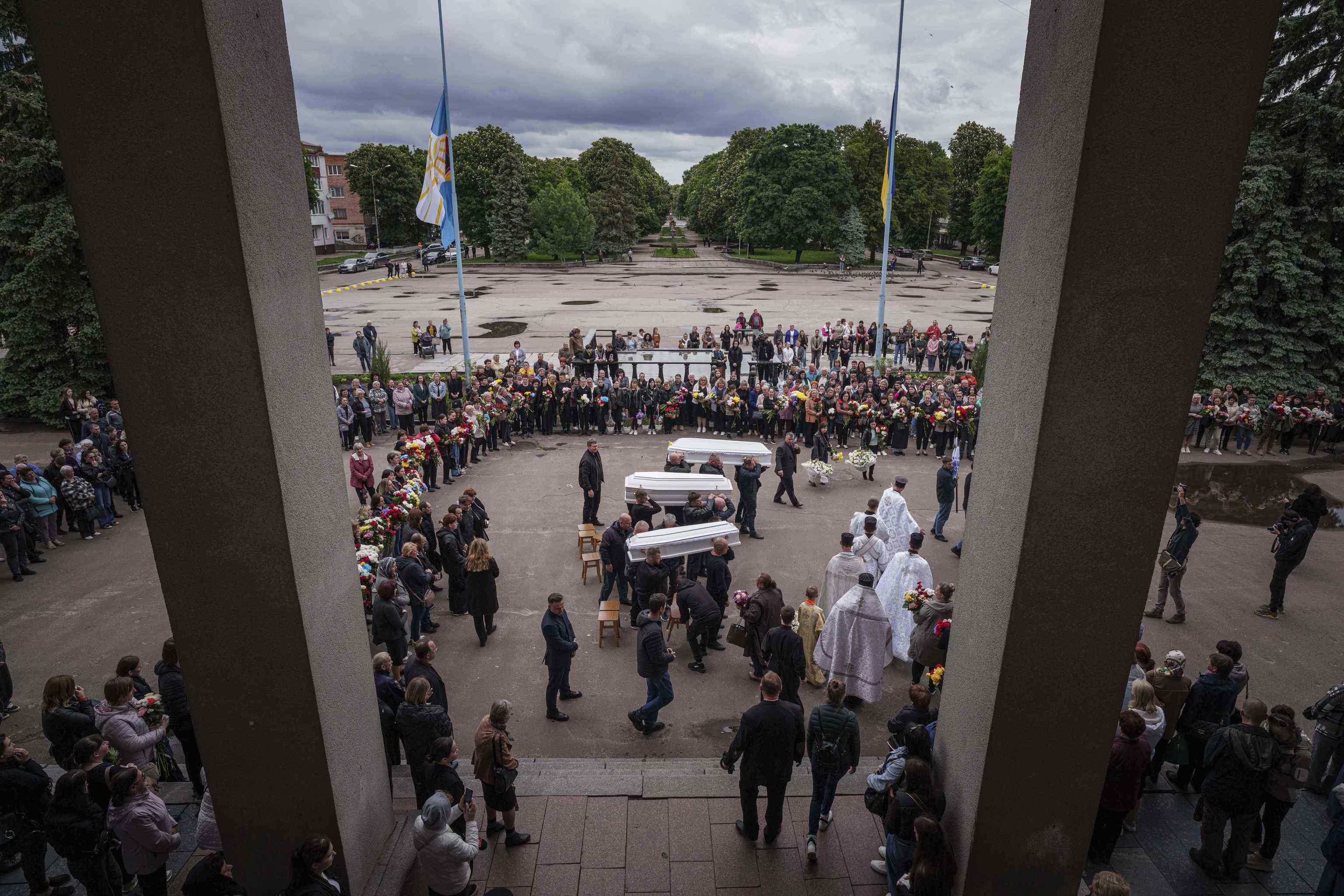 Funeral workers carry coffins during a funeral ceremony.