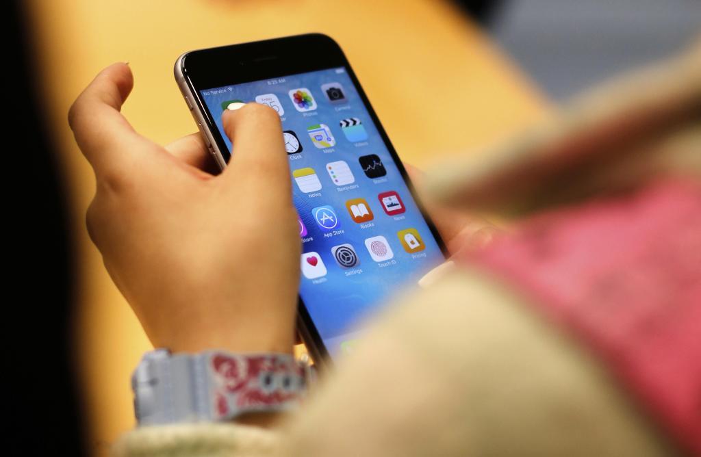 A child holds an iPhone at an Apple.