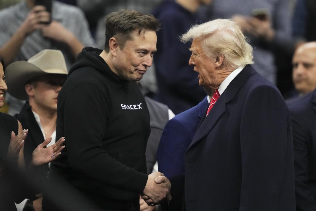 Elon Musk, left, shakes hands with US President Donald Trump